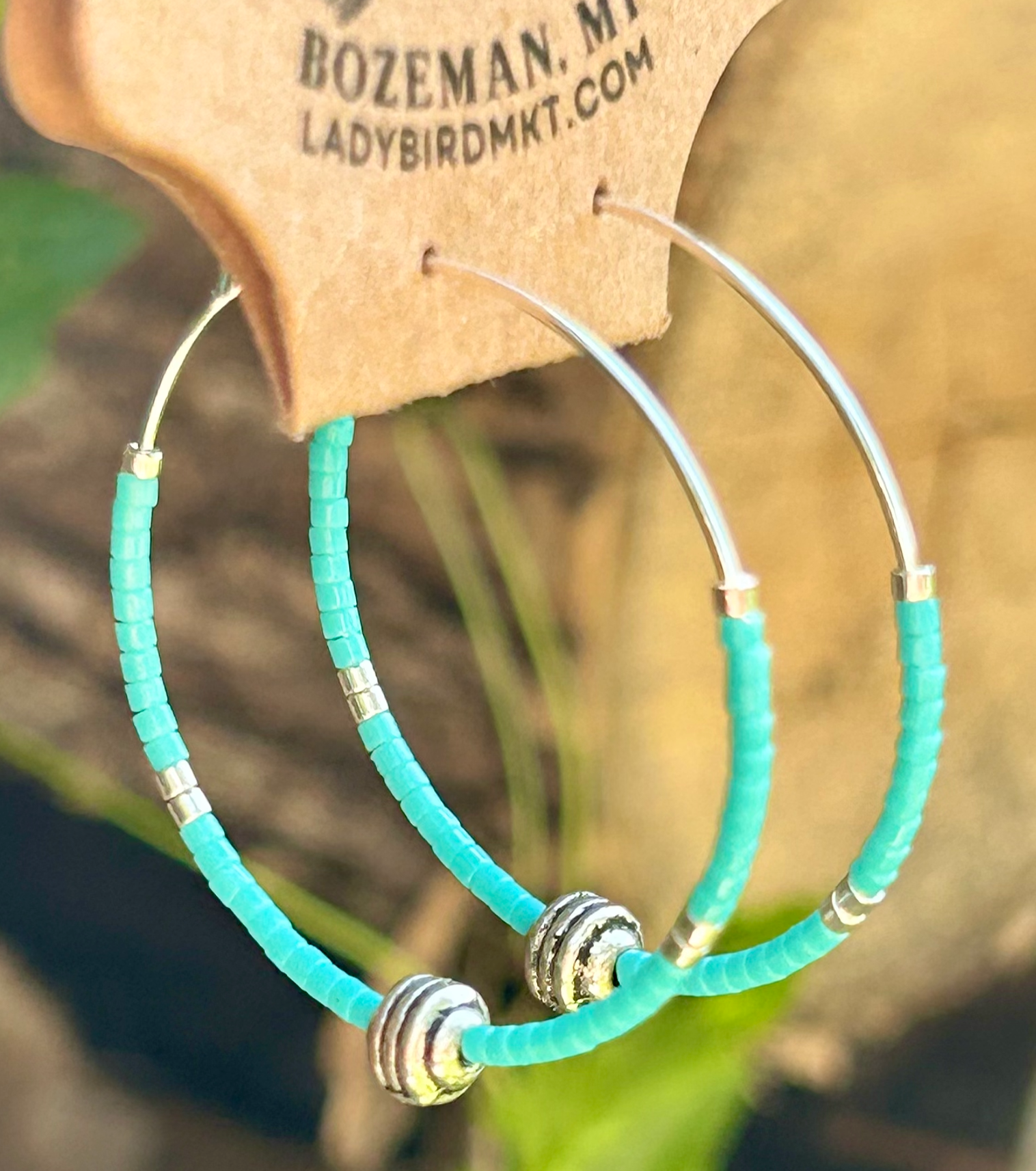 Turquoise and silver beaded hoop earrings featuring Miyuki Delica seed beads on a stainless steel hoop, showcasing a vibrant bohemian design.