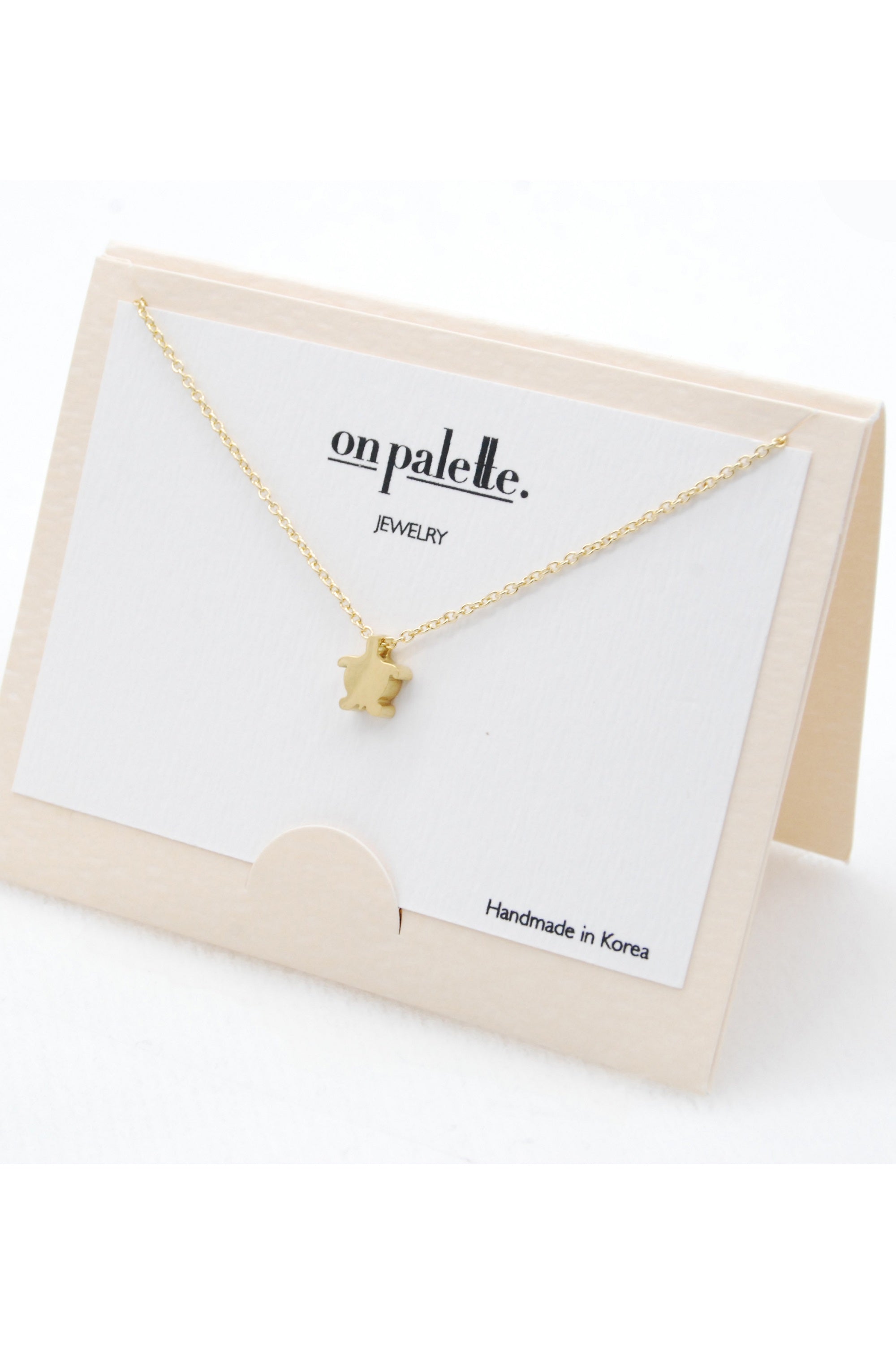 A stylish Turtle Pendant Necklace by DOBBI, featuring a turtle-shaped pendant made of stainless steel, available in various colors.