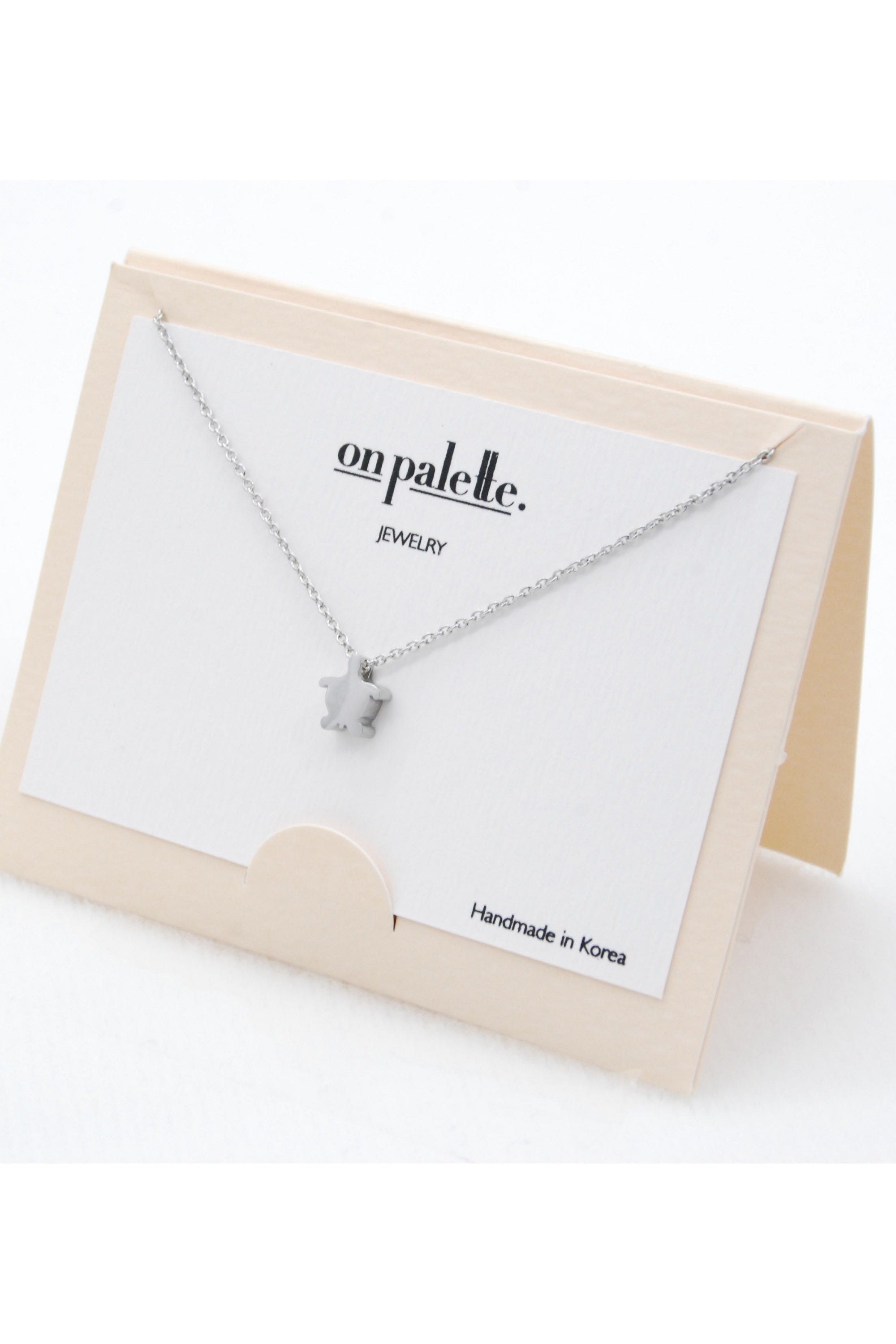A stylish Turtle Pendant Necklace by DOBBI, featuring a turtle-shaped pendant made of stainless steel, available in various colors.