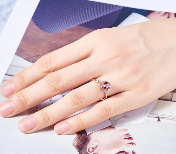 Twisted Pink Austrian Elements Circular Halo Adjustable Ring featuring 14K rose gold plating and pink stones, elegantly designed for comfort.