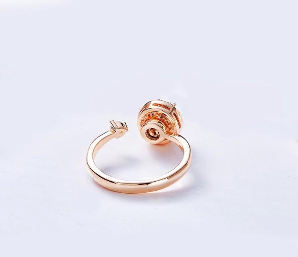 Twisted Pink Austrian Elements Circular Halo Adjustable Ring featuring 14K rose gold plating and pink stones, elegantly designed for comfort.