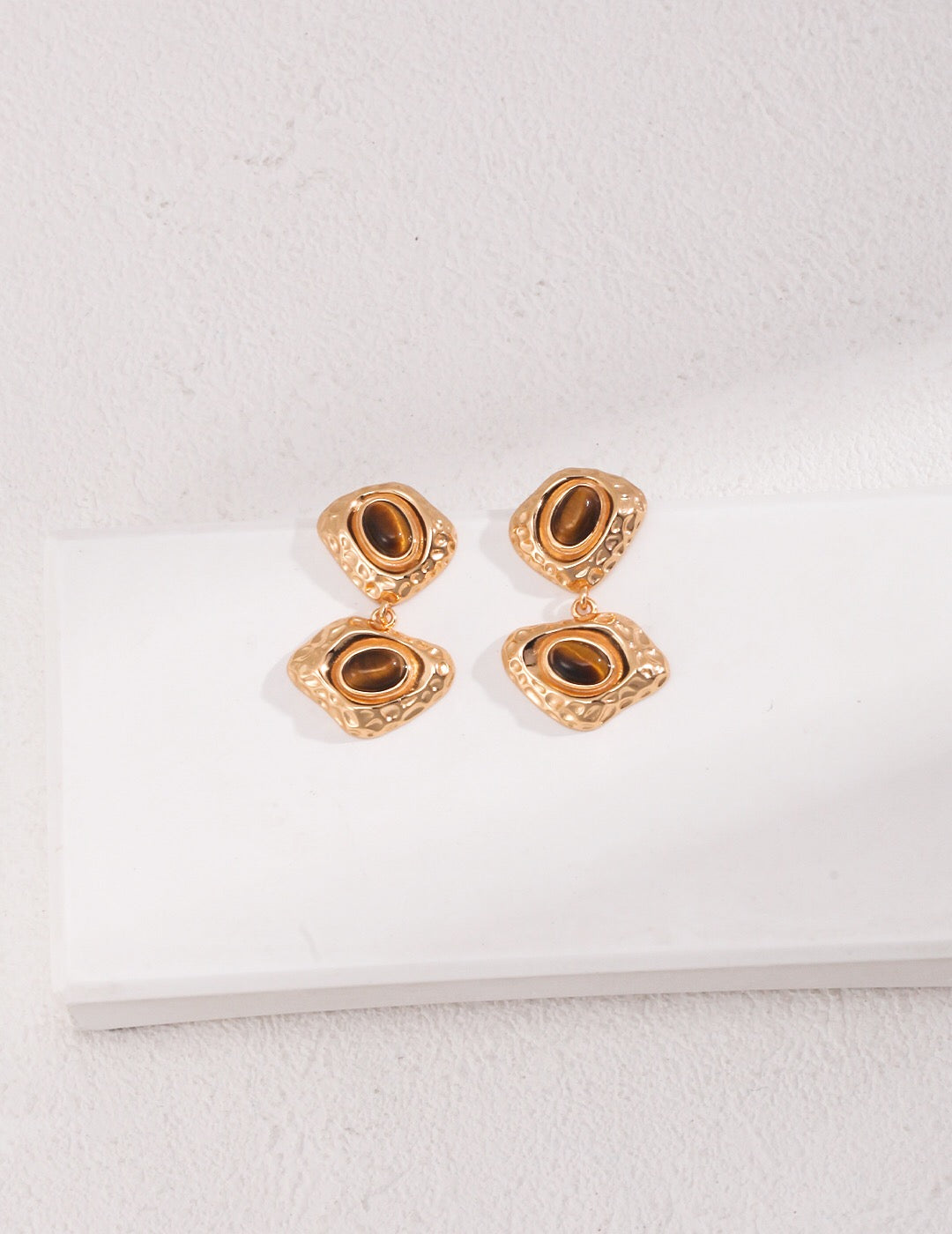 Two handmade irregular Tiger's Eye stone earrings set in sterling silver and gold vermeil, showcasing unique shapes and rich colors.