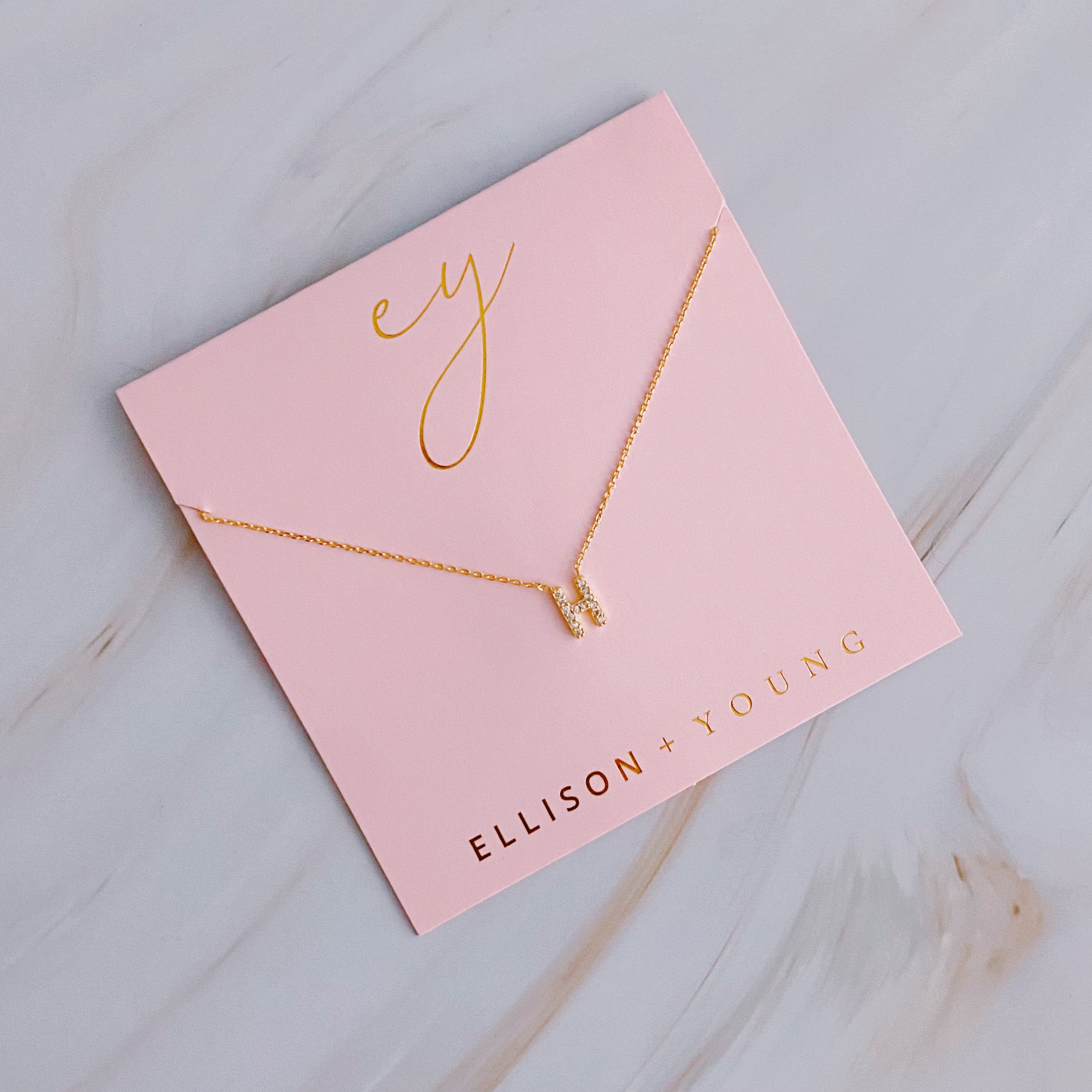 A delicate Understated Beauty Initial Necklace featuring a gold plated initial pendant adorned with sparkling cubic zirconia stones.