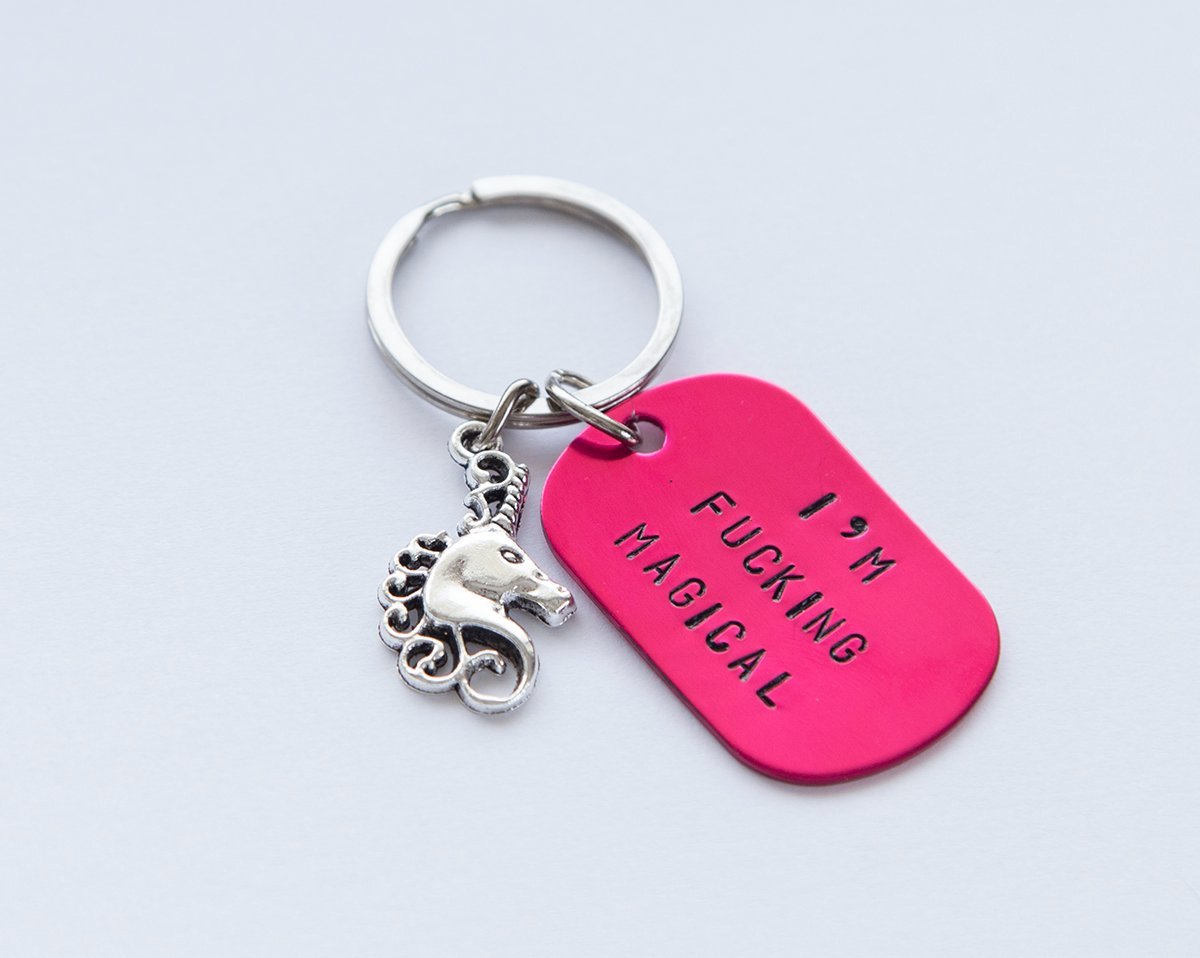 A pink hand-stamped unicorn keychain with a stainless steel keyring, showcasing a unique and whimsical design.