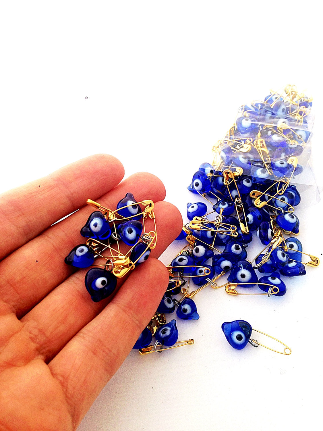 A collection of 25 tiny heart-shaped glass evil eye beads, ideal for wedding favors and baby showers, symbolizing protection and luck.