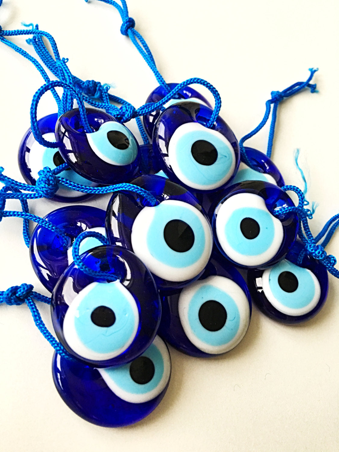 A collection of unique Turkish evil eye beads, each measuring 3.5cm, displayed with a blue rope for hanging, perfect as wedding favors.