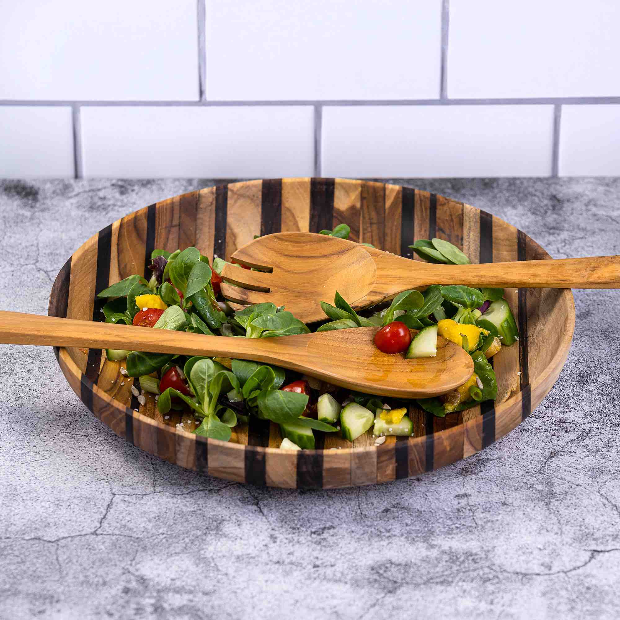 Upcycled eco-friendly wooden salad servers made from reclaimed teak wood, showcasing unique grain patterns and a polished finish.