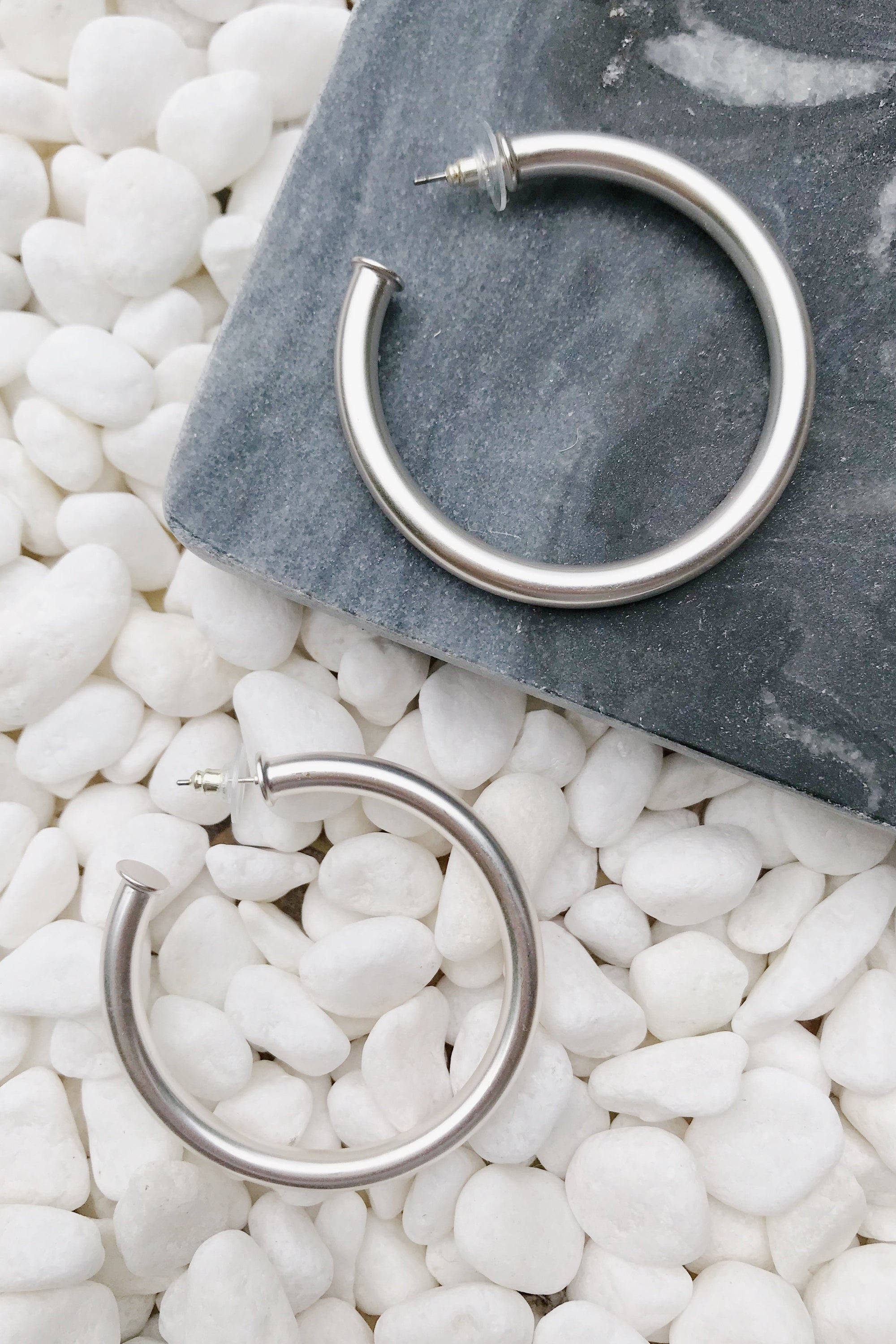 Upper Class Taste Hoop Earrings in matte silver finish, featuring a lightweight tube style and 2-inch diameter, perfect for stylish and classy looks.