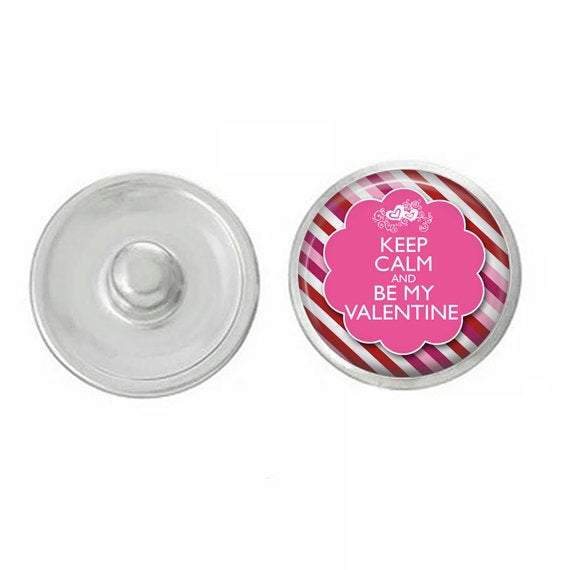 A hand-pressed 7/8” round snap featuring the phrase 'Keep Calm and Be My Valentine' with a Cupid design, perfect for Valentine's Day jewelry.