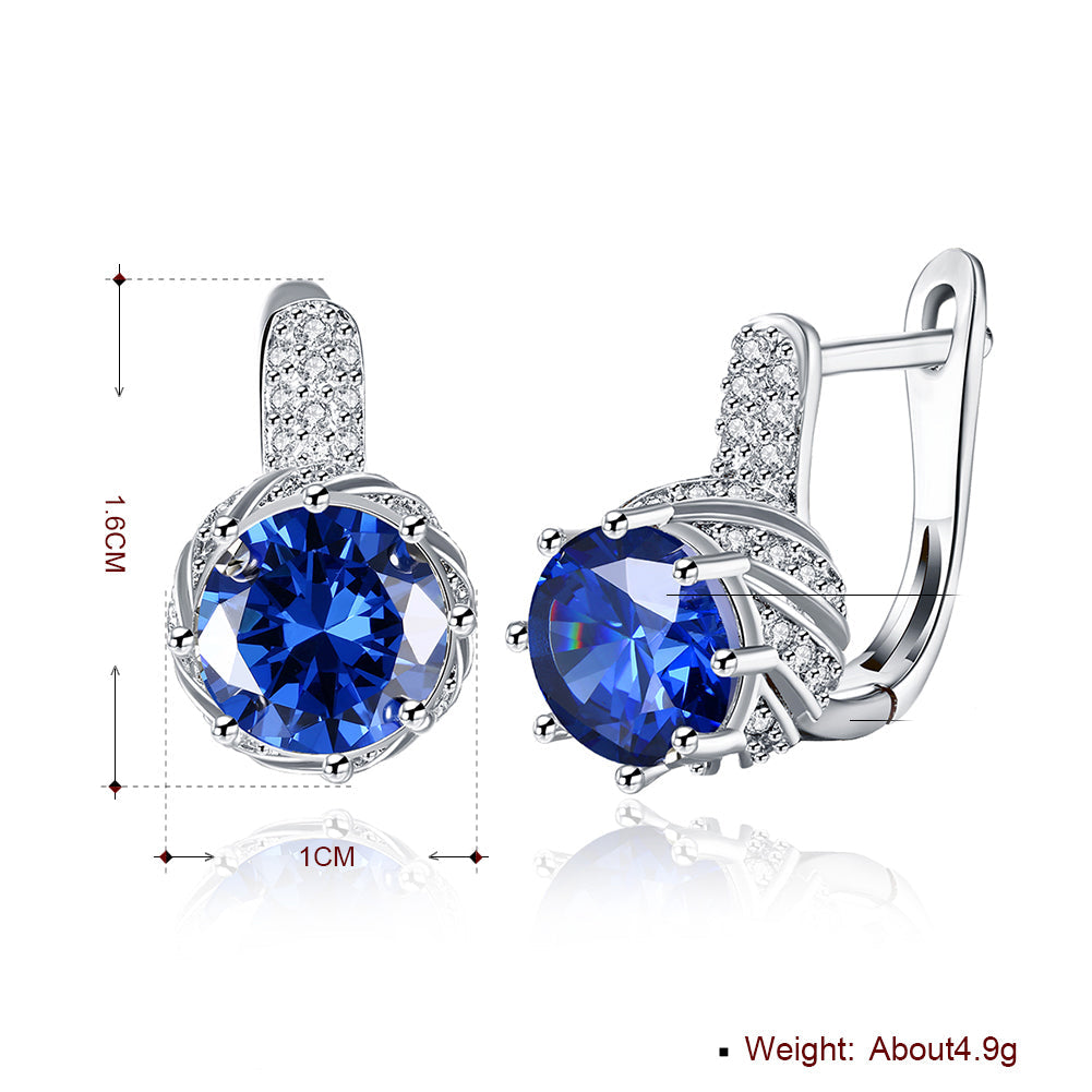 Vienna 1.00 Ct Sapphire Round Cut Huggie Earring in 18K White Gold, showcasing brilliant sapphires and elegant design.