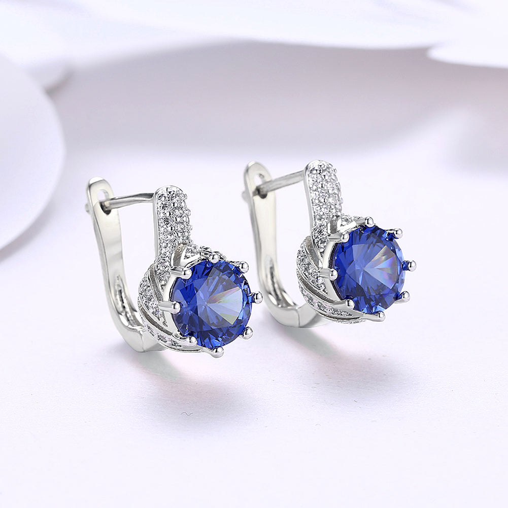 Vienna 1.00 Ct Sapphire Round Cut Huggie Earring in 18K White Gold, showcasing brilliant sapphires and elegant design.