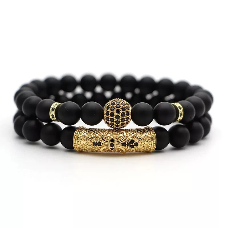 Vortex Bracelet Set featuring two black onyx bracelets with zirconia encrusted spacers in various metal colors.