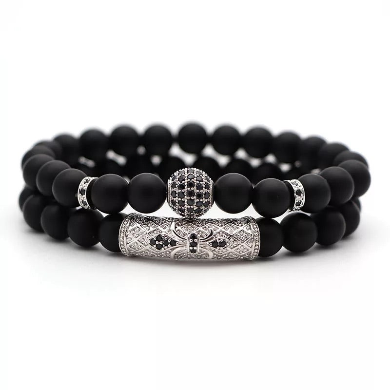 Vortex Bracelet Set featuring two black onyx bracelets with zirconia encrusted spacers in various metal colors.