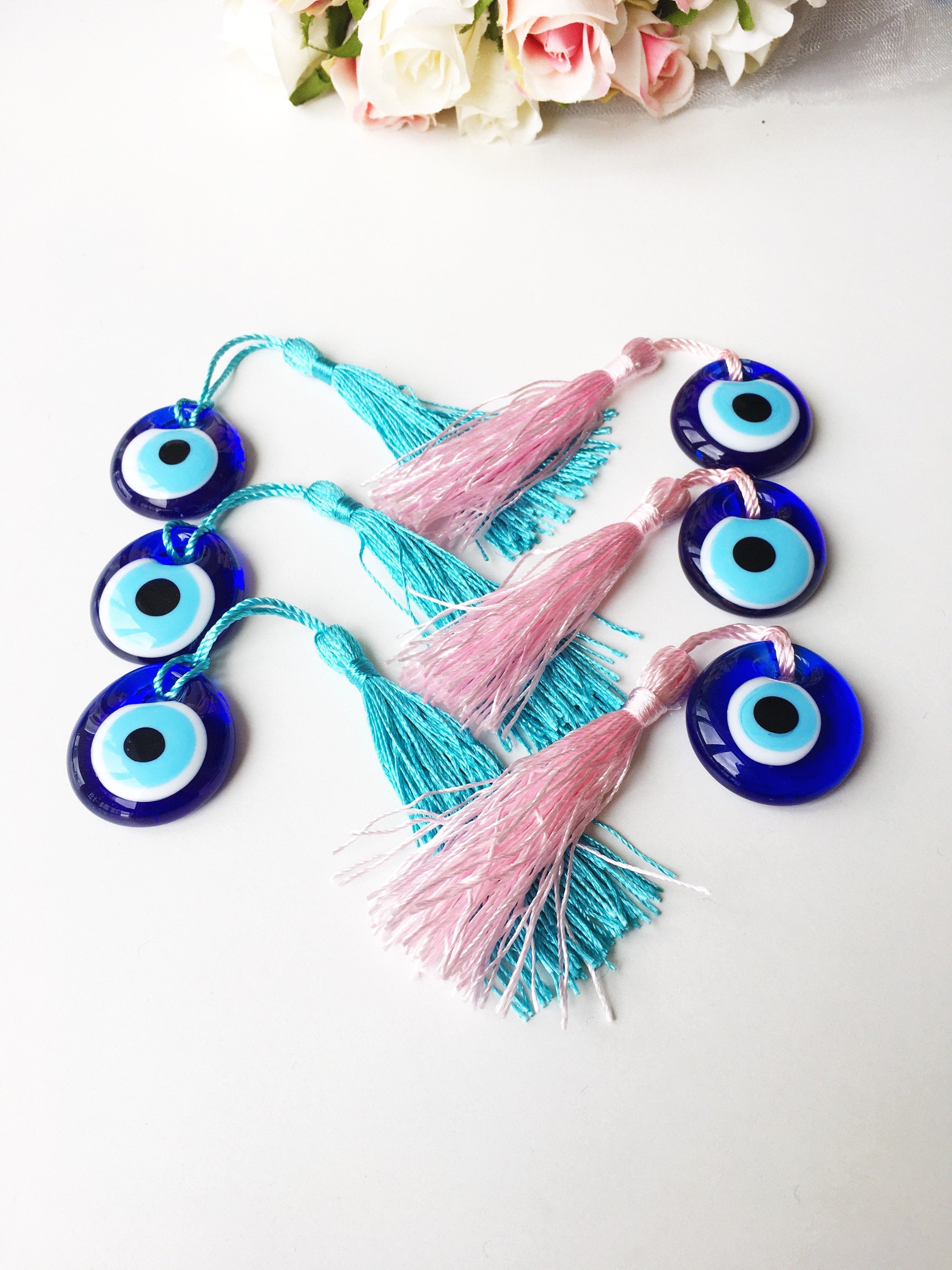 A collection of 50 blue glass evil eye beads with tassels, symbolizing protection and good luck, perfect for wedding favors.