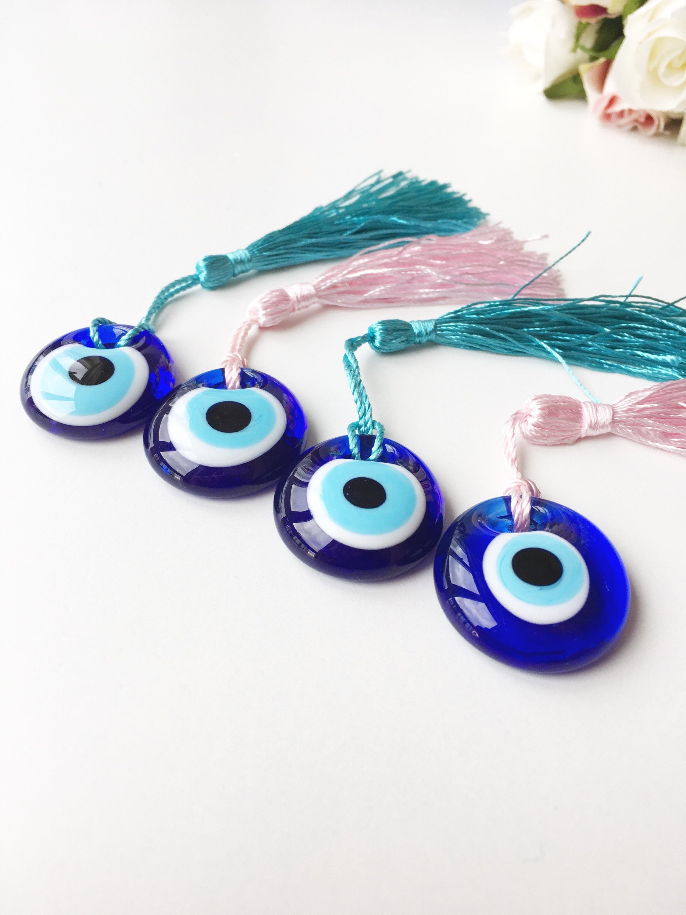 A collection of 50 blue glass evil eye beads with tassels, symbolizing protection and good luck, perfect for wedding favors.