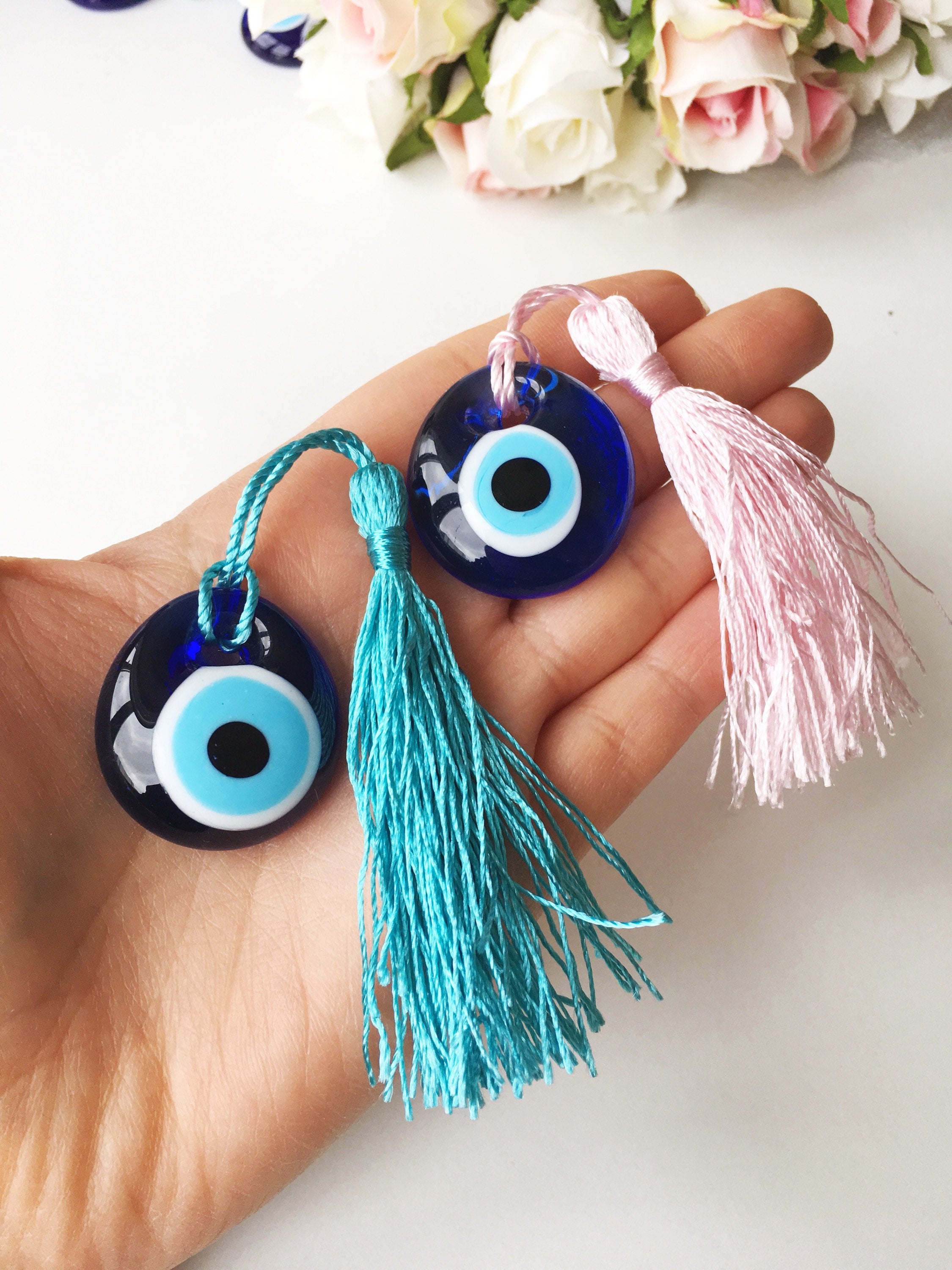 A collection of 50 blue glass evil eye beads with tassels, symbolizing protection and good luck, perfect for wedding favors.