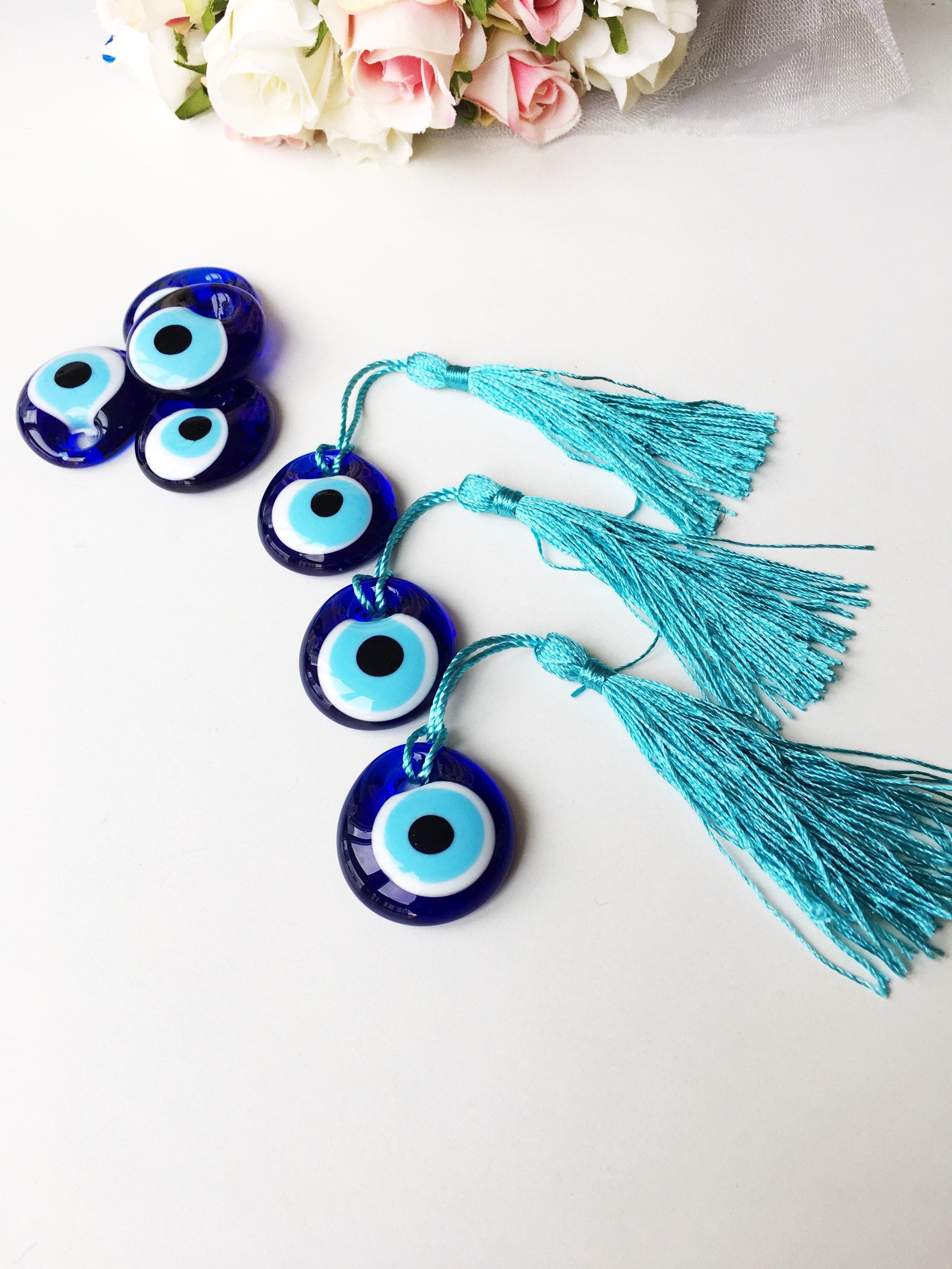 A collection of 50 blue glass evil eye beads with tassels, symbolizing protection and good luck, perfect for wedding favors.