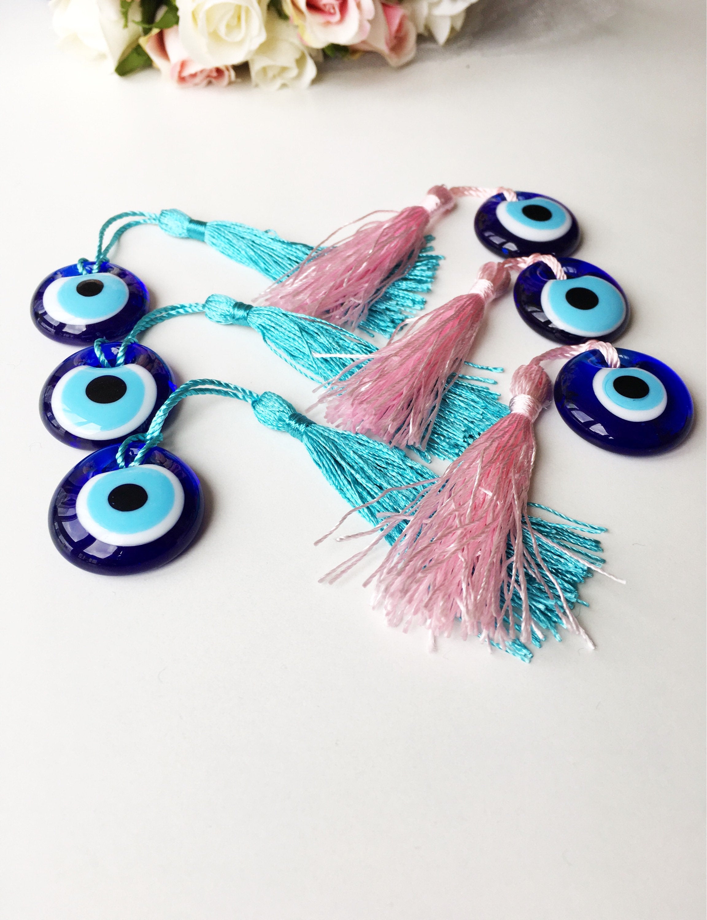 A collection of 50 blue glass evil eye beads with tassels, symbolizing protection and good luck, perfect for wedding favors.