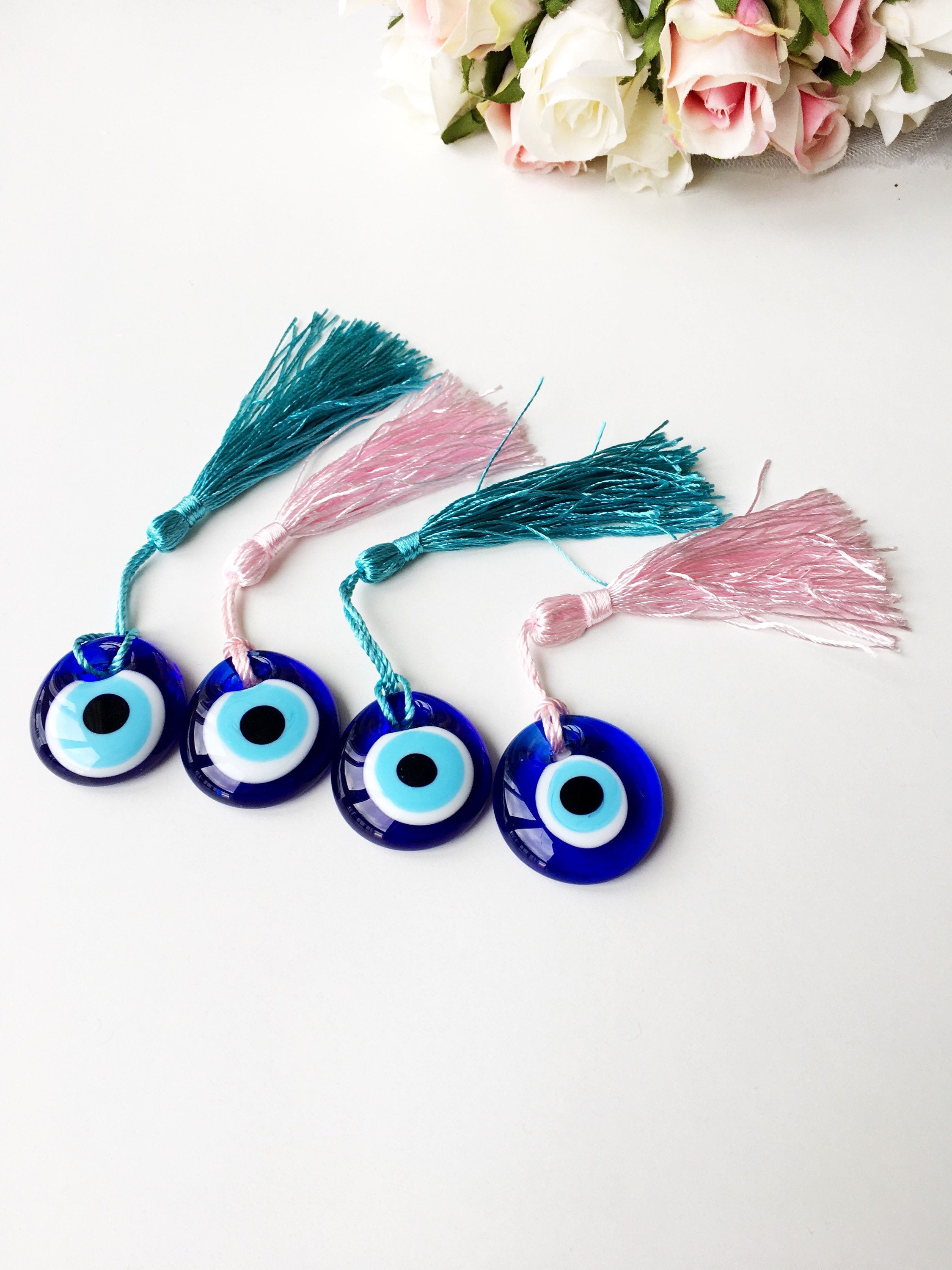 A collection of 50 blue glass evil eye beads with tassels, symbolizing protection and good luck, perfect for wedding favors.