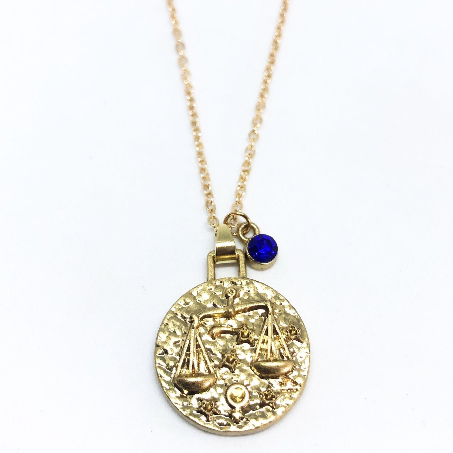 A beautiful 24K gold plated zodiac necklace featuring a double-sided pendant with astrological sign on one side and zodiac sign stamped on the other.