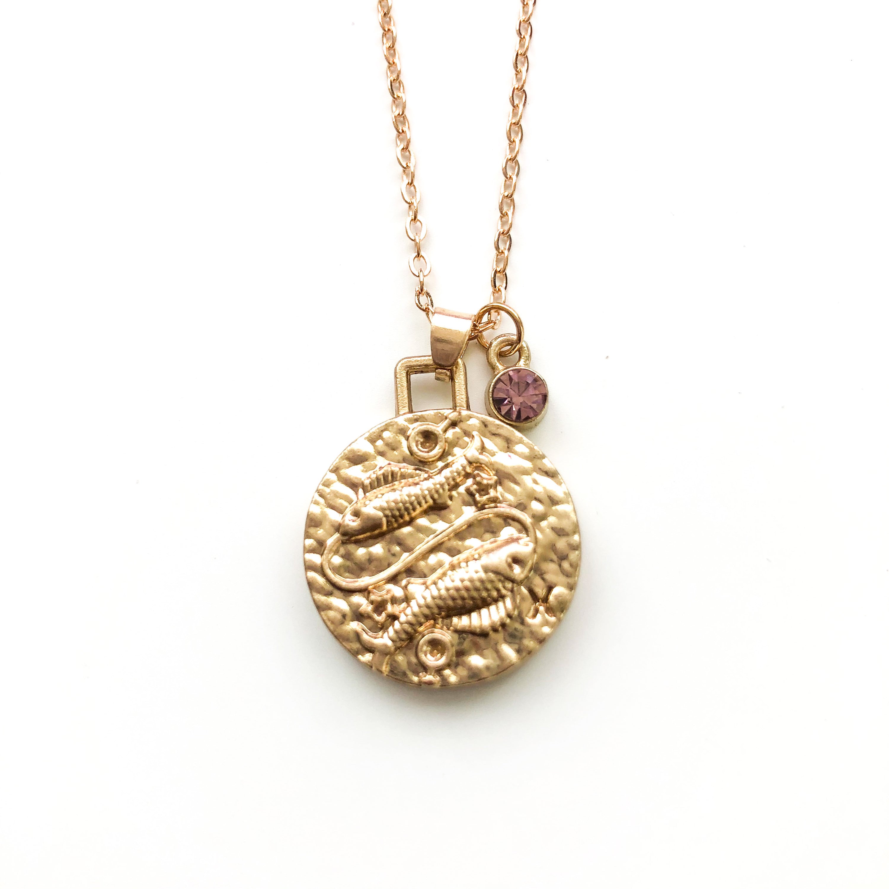 A beautiful 24K gold plated zodiac necklace featuring a double-sided pendant with astrological sign on one side and zodiac sign stamped on the other.