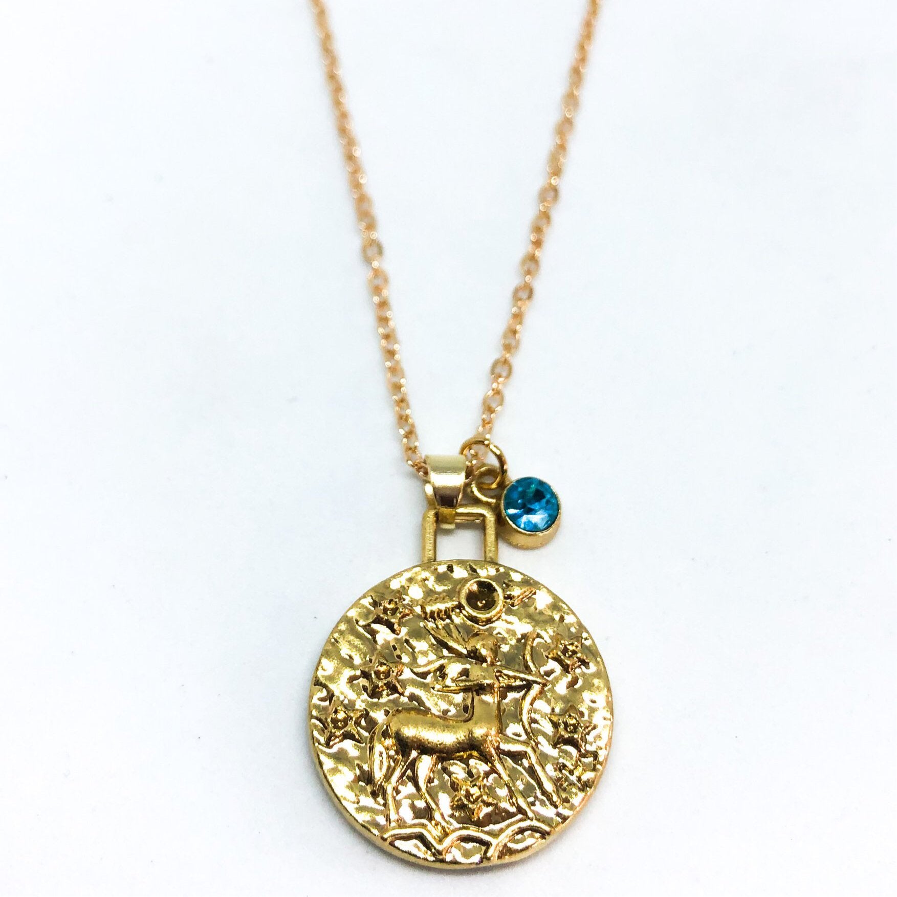 A beautiful 24K gold plated zodiac necklace featuring a double-sided pendant with astrological sign on one side and zodiac sign stamped on the other.
