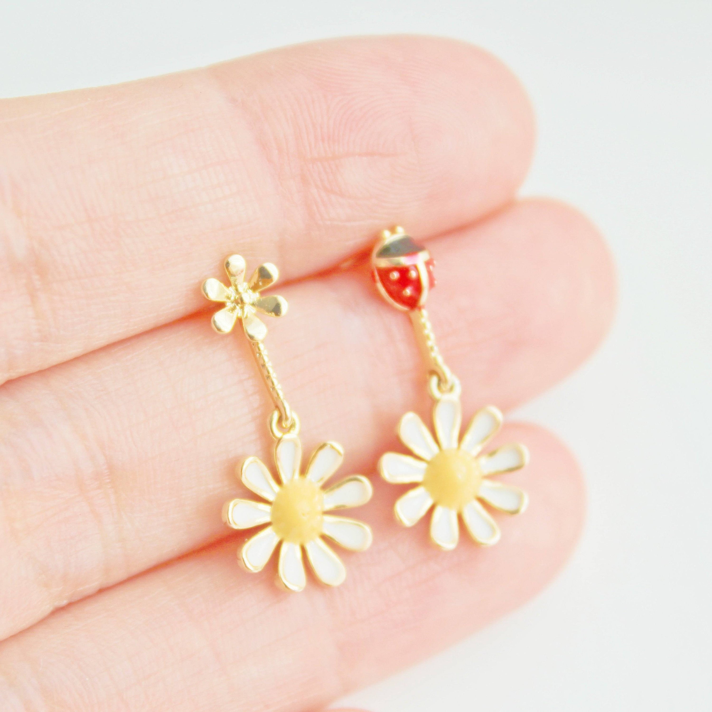 A pair of White Daisy Flower and Ladybird Mini Drop Mismatch Earrings featuring sterling silver ear studs and gold-coated bronze bodies.