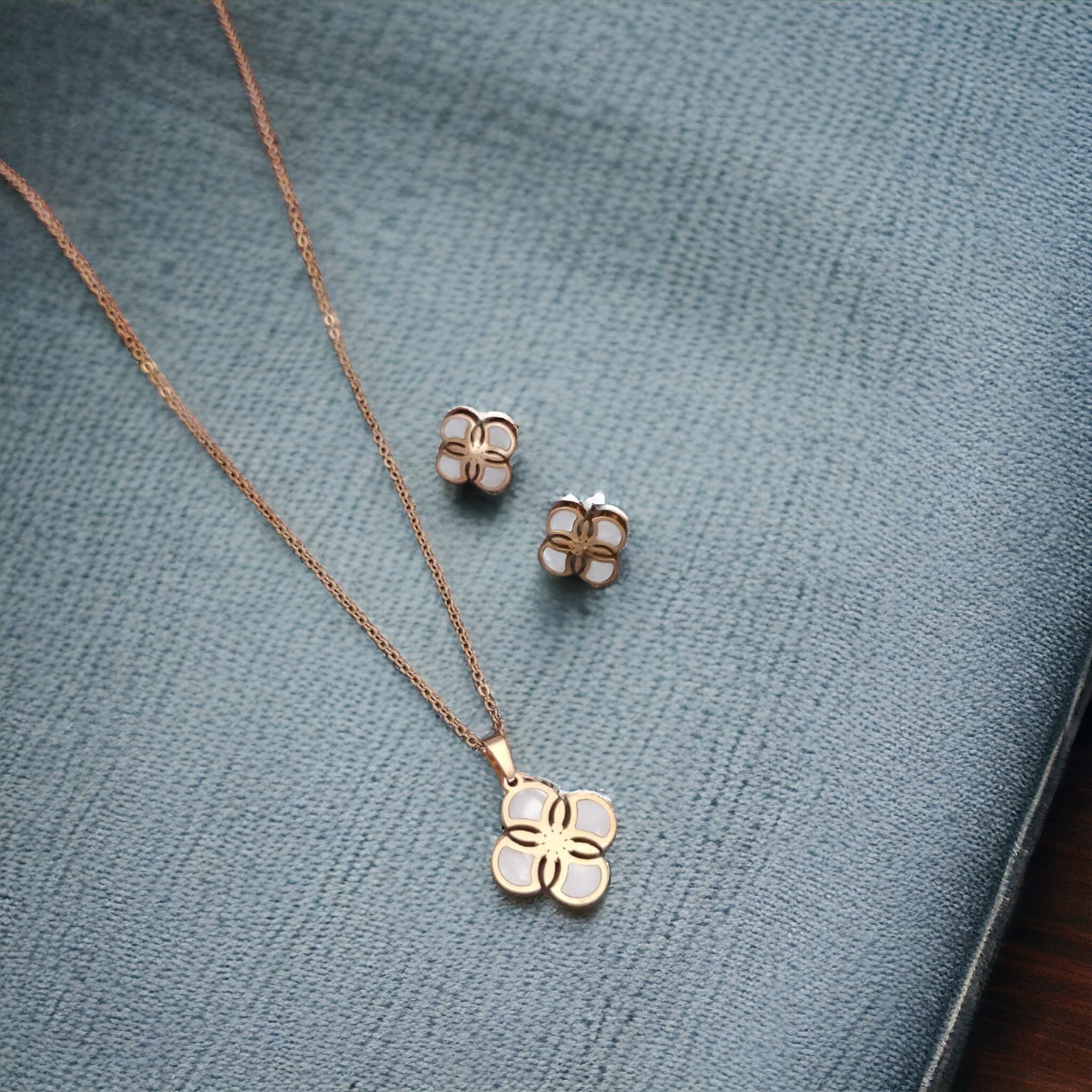 White Enamel Minimalistic Clover Pendant Necklace and Earring Set featuring a rotating clover pendant, crafted from 18ct gold-plated material.