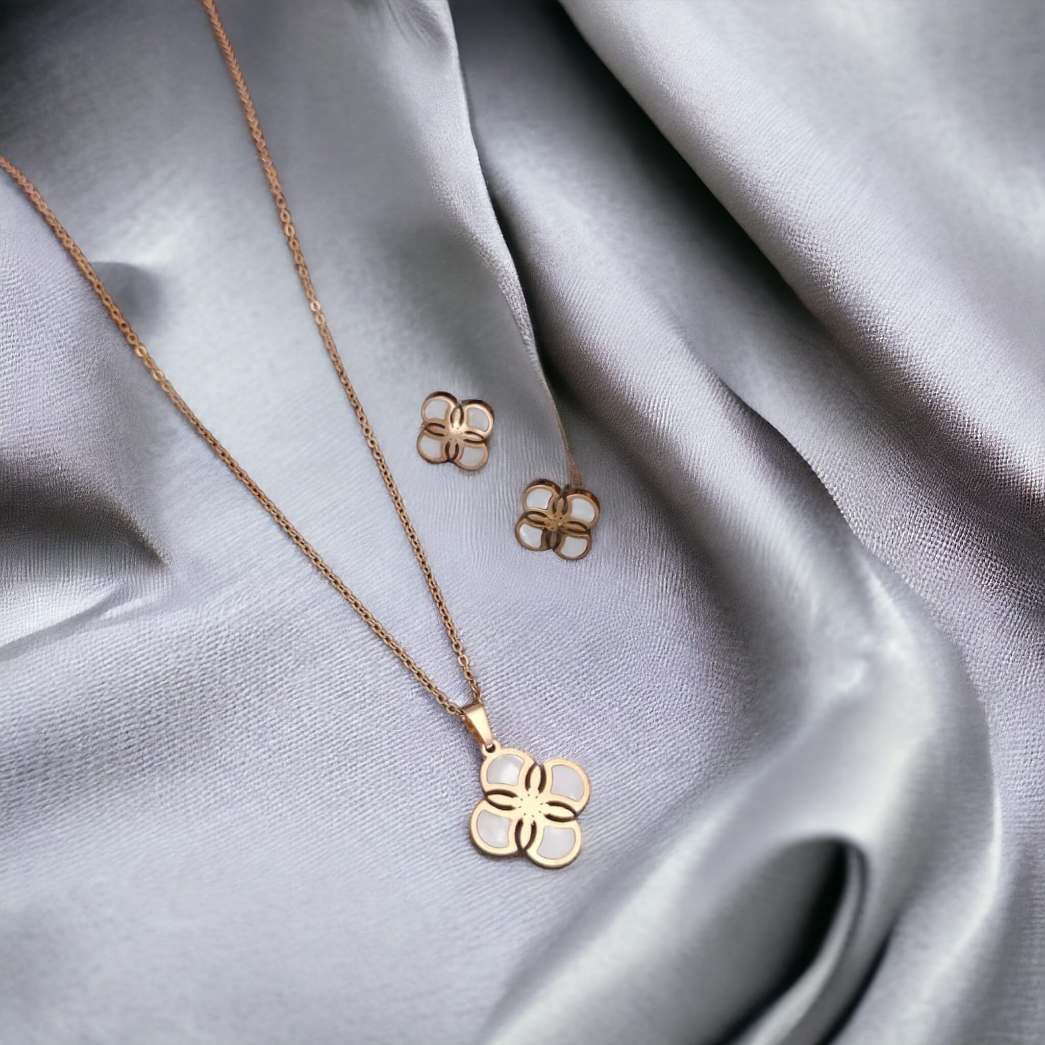White Enamel Minimalistic Clover Pendant Necklace and Earring Set featuring a rotating clover pendant, crafted from 18ct gold-plated material.