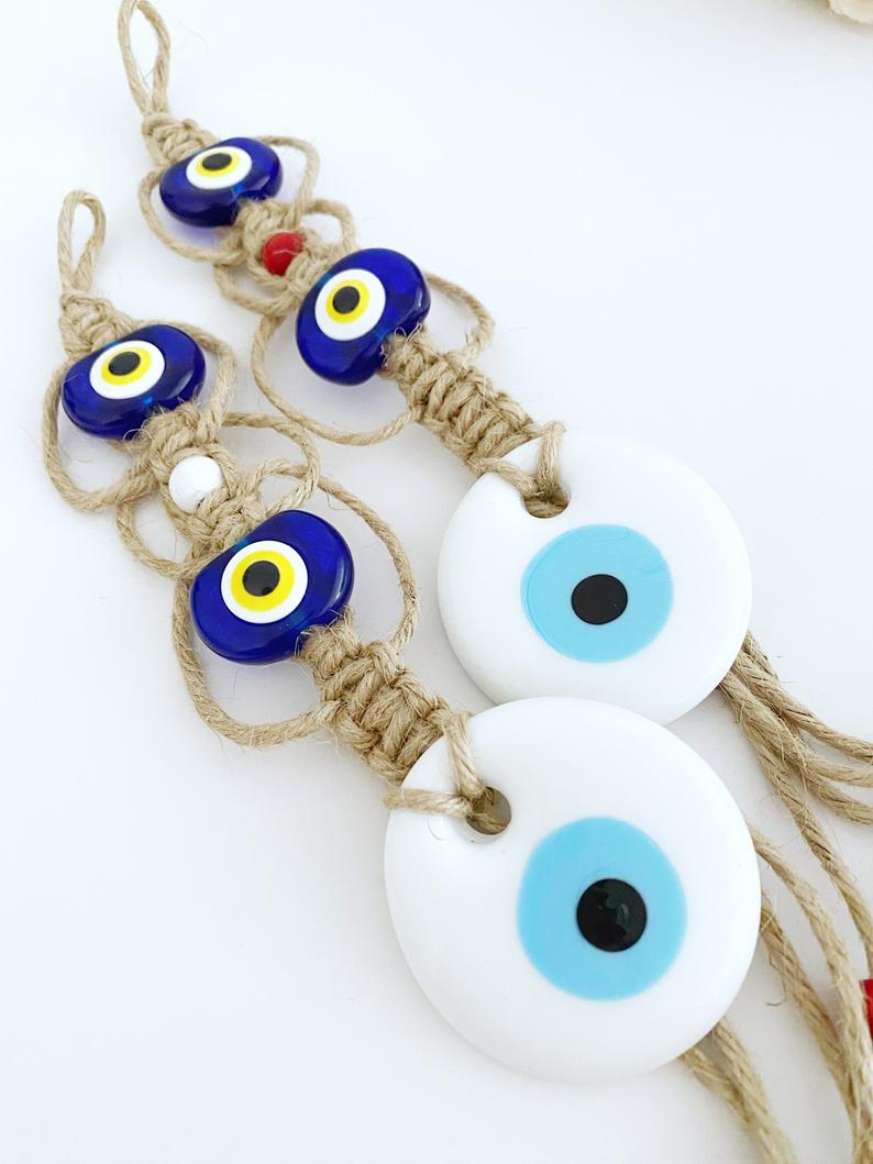 Handmade White Evil Eye Bead Wall Hanging featuring macrame design with blue plastic beads, perfect for home decor and protection.