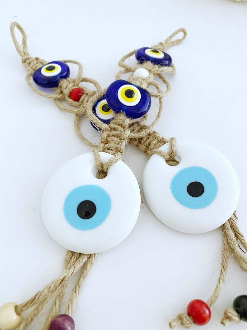 Handmade White Evil Eye Bead Wall Hanging featuring macrame design with blue plastic beads, perfect for home decor and protection.