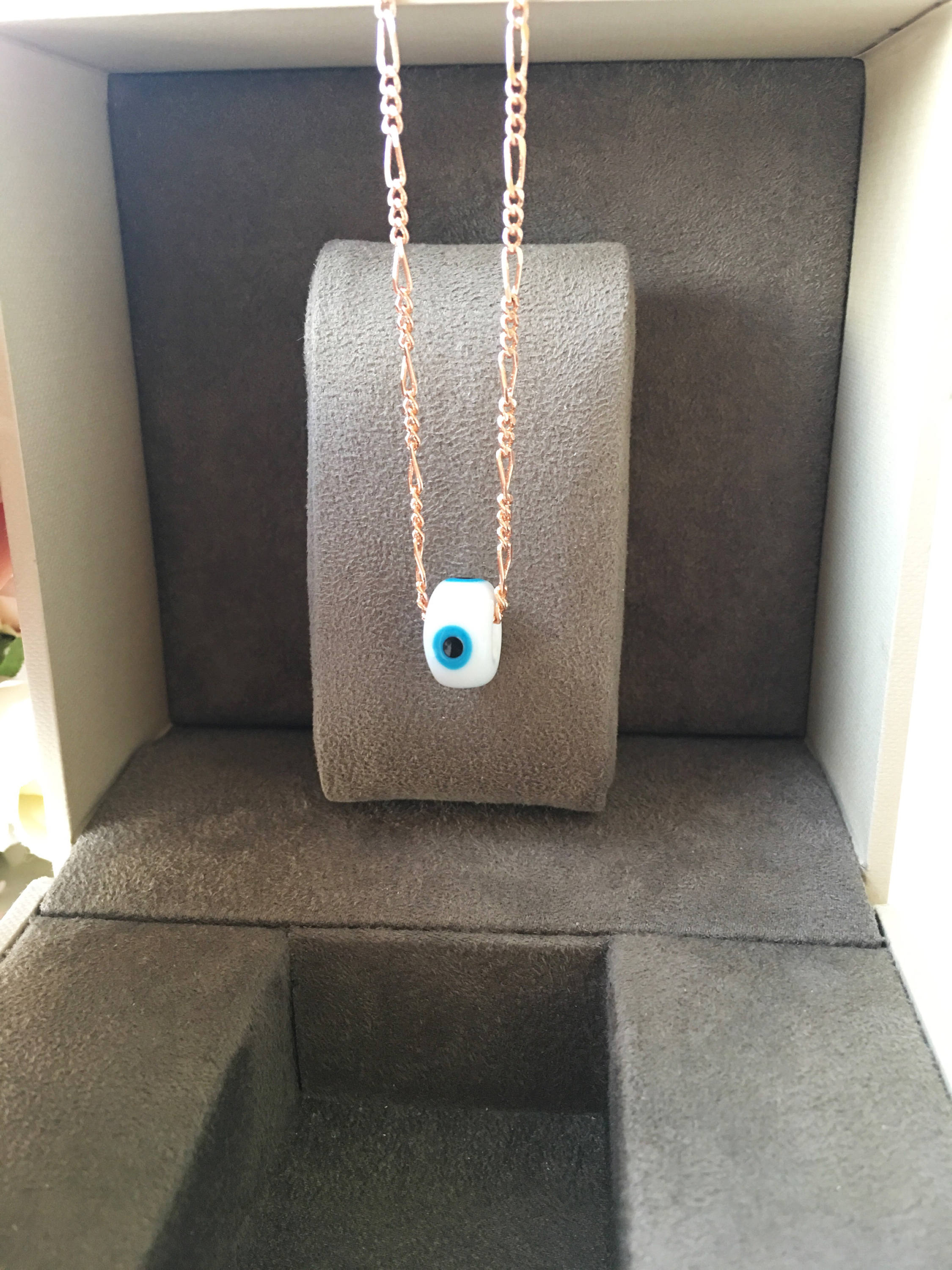 Handmade white evil eye necklace featuring Murano glass beads and a rose gold stainless steel chain, symbolizing protection and style.