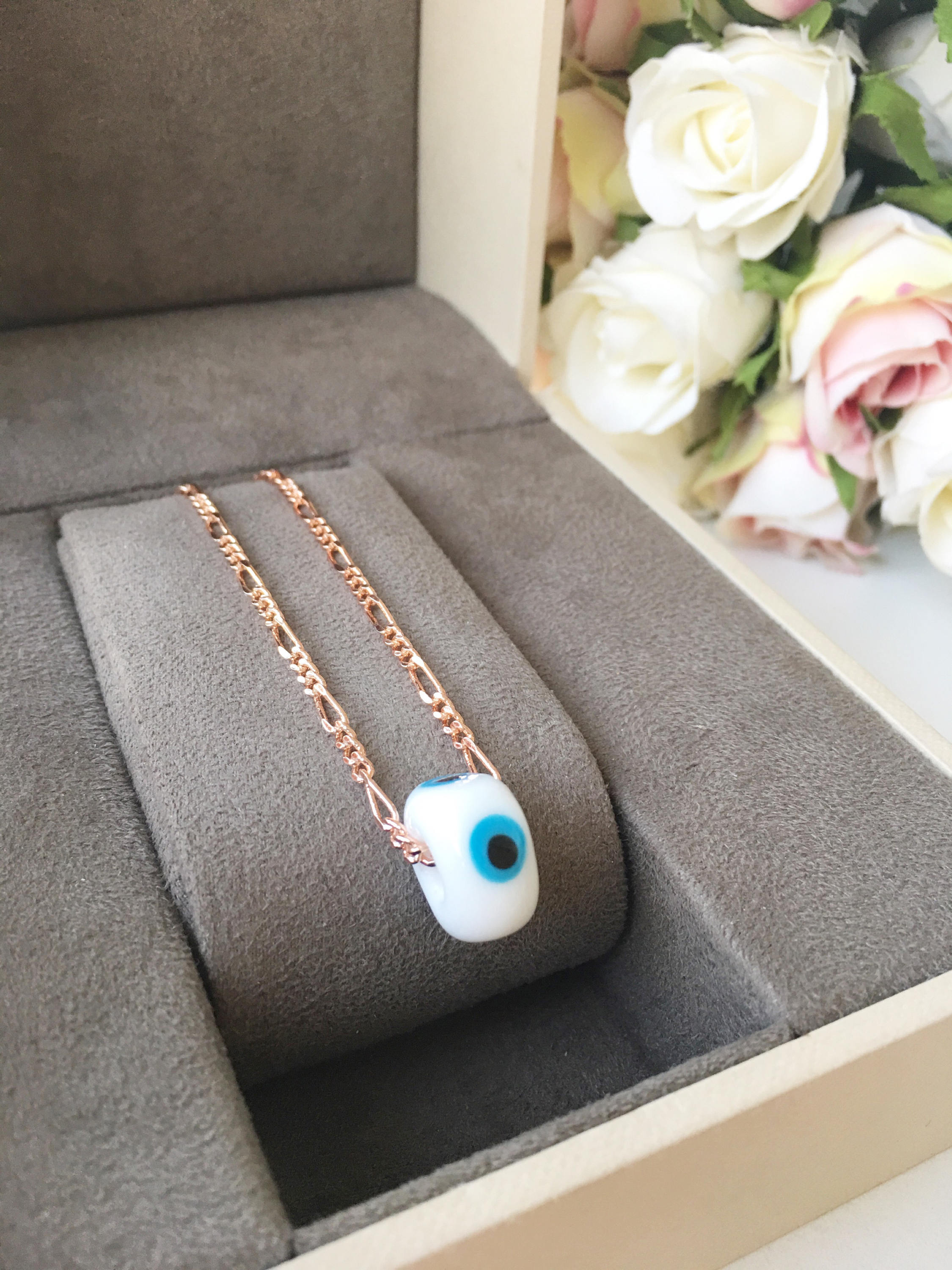 Handmade white evil eye necklace featuring Murano glass beads and a rose gold stainless steel chain, symbolizing protection and style.