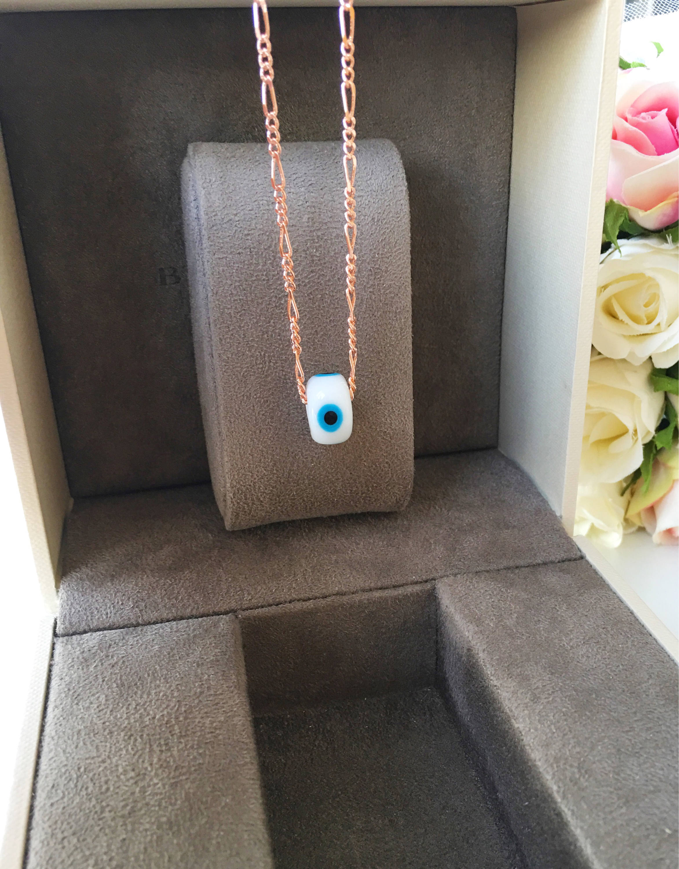 Handmade white evil eye necklace featuring Murano glass beads and a rose gold stainless steel chain, symbolizing protection and style.