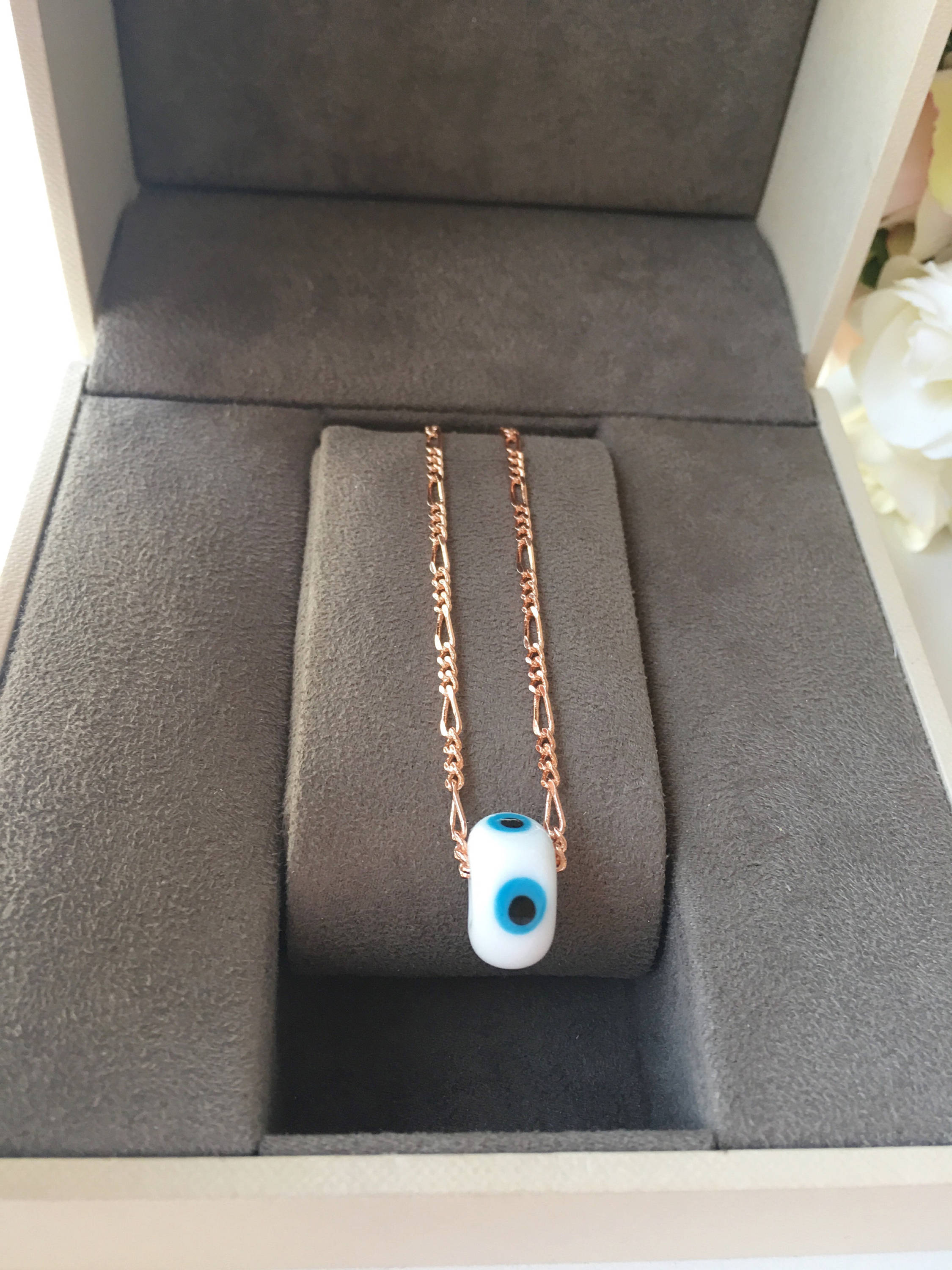 Handmade white evil eye necklace featuring Murano glass beads and a rose gold stainless steel chain, symbolizing protection and style.
