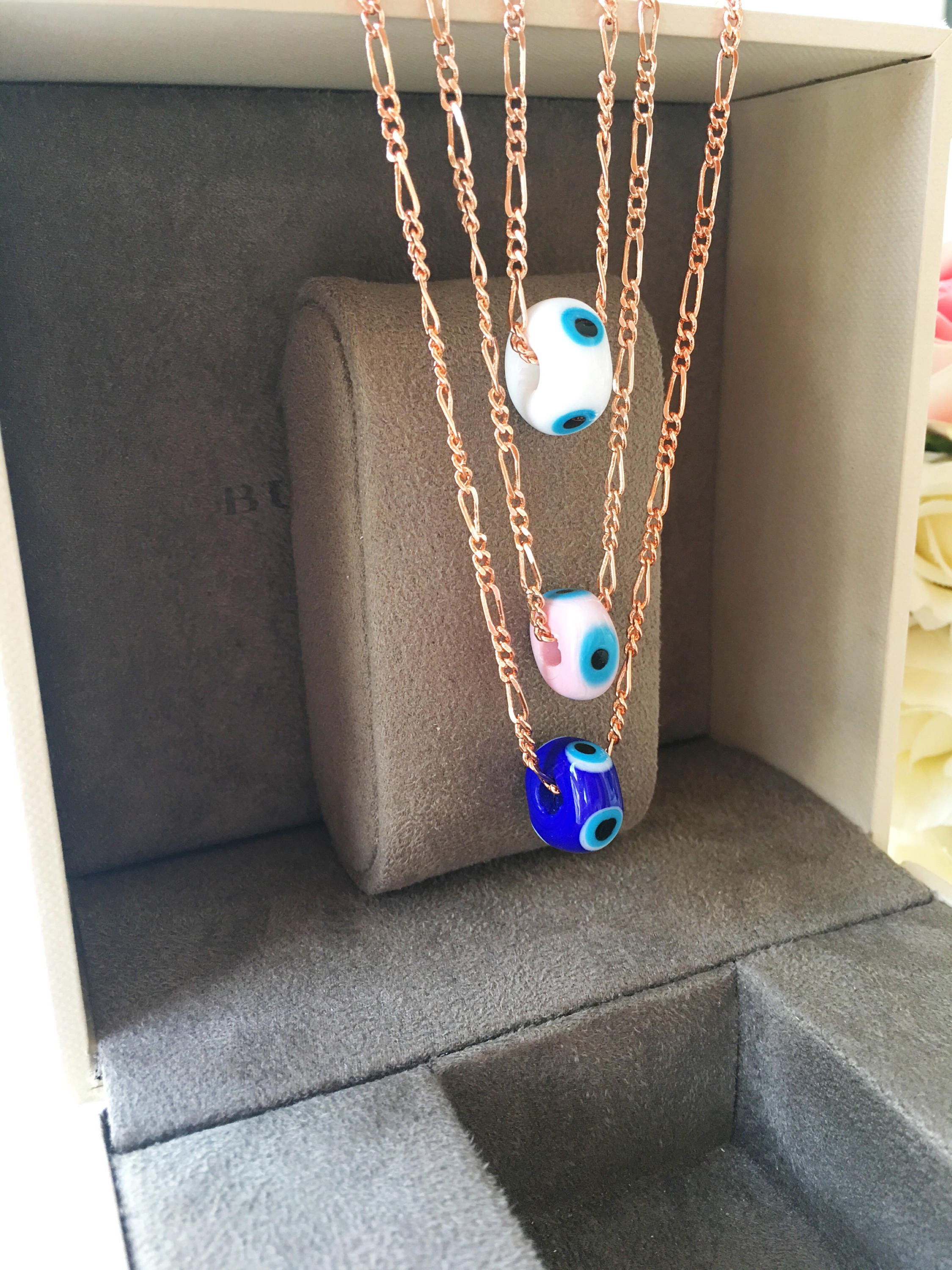 Handmade white evil eye necklace featuring Murano glass beads and a rose gold stainless steel chain, symbolizing protection and style.