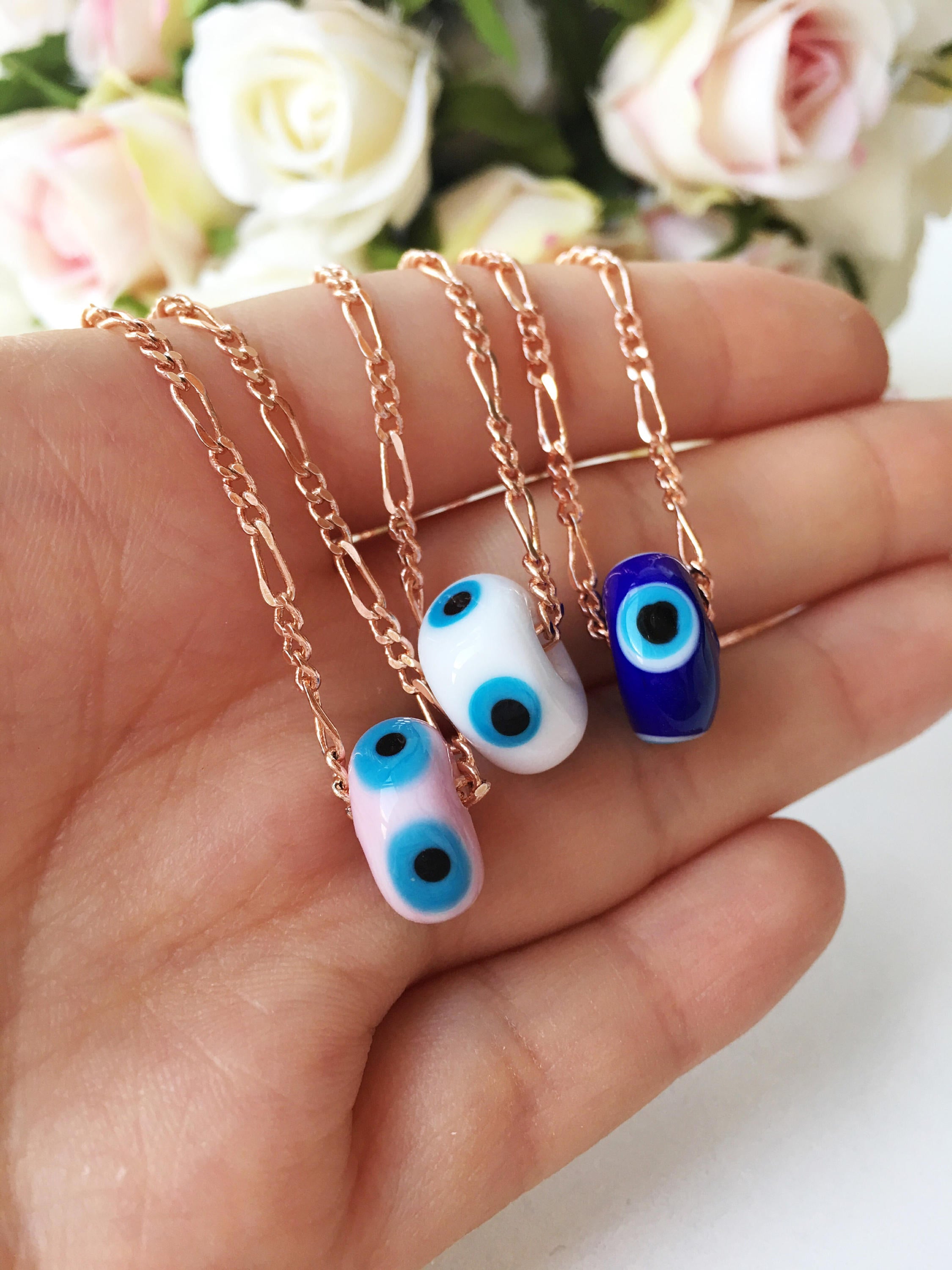 Handmade white evil eye necklace featuring Murano glass beads and a rose gold stainless steel chain, symbolizing protection and style.