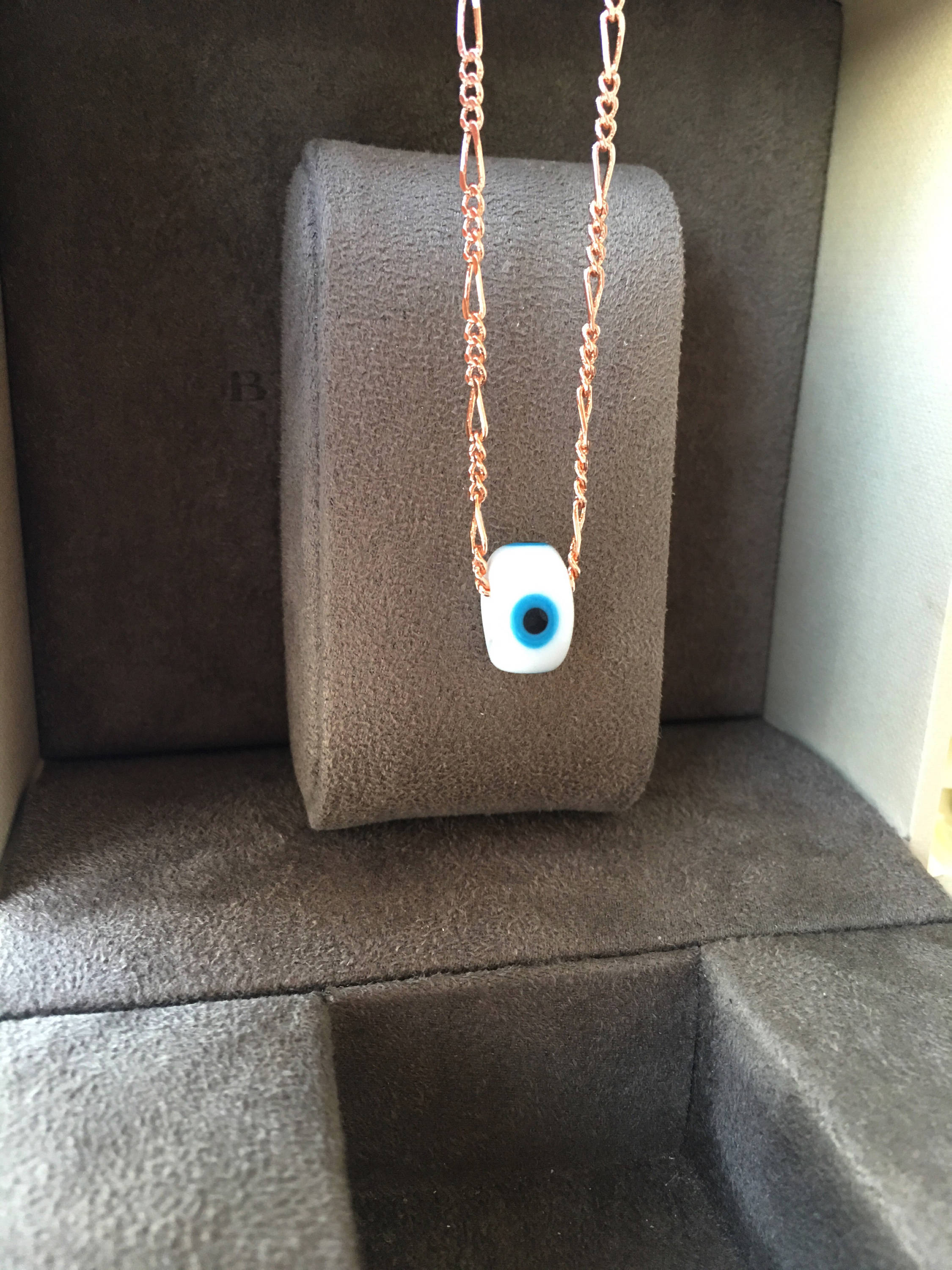 Handmade white evil eye necklace featuring Murano glass beads and a rose gold stainless steel chain, symbolizing protection and style.