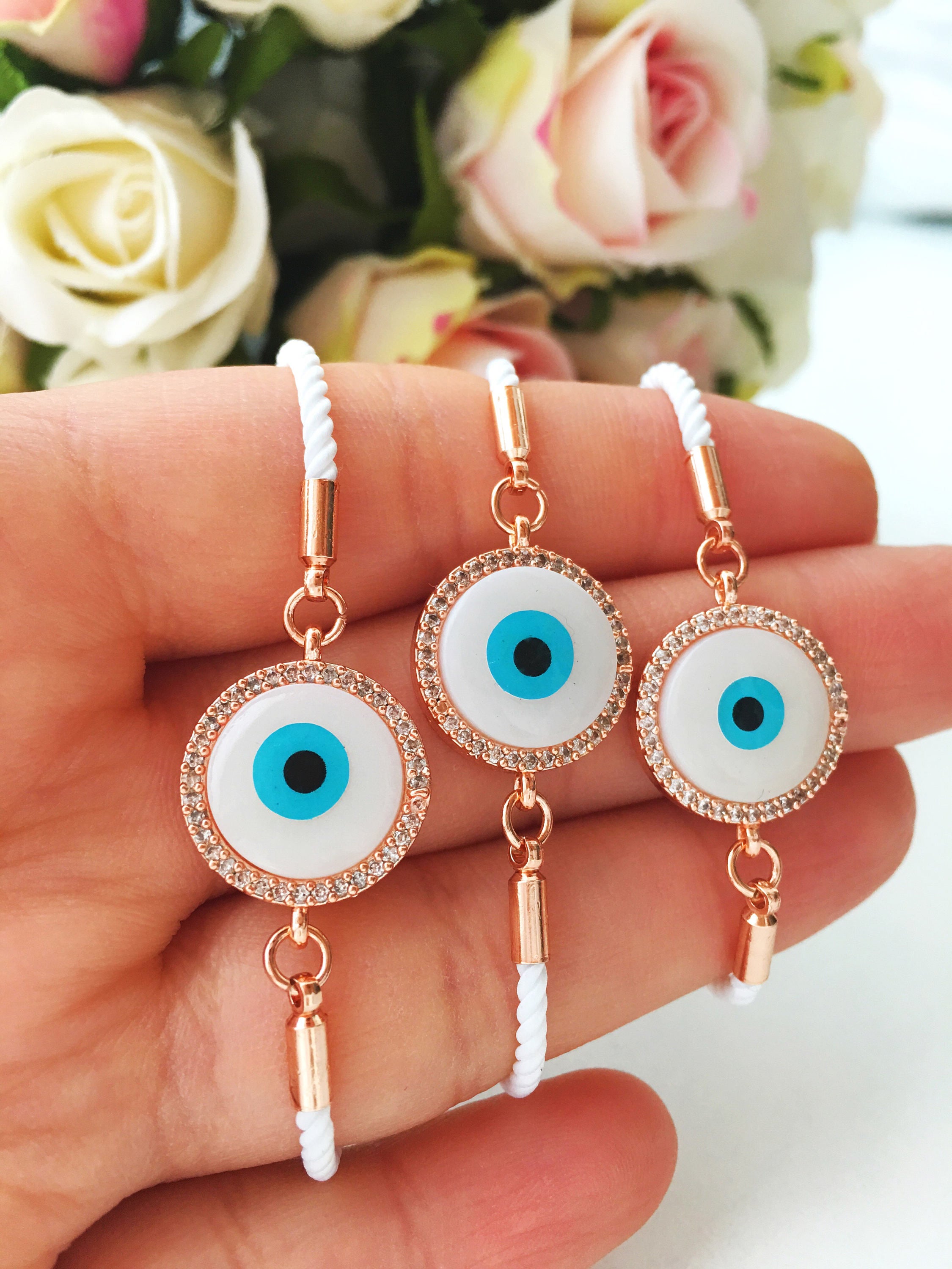 A beautifully crafted White Evil Eye Bracelet featuring a mother of pearl centerpiece, adjustable white string, and zirconia accents.