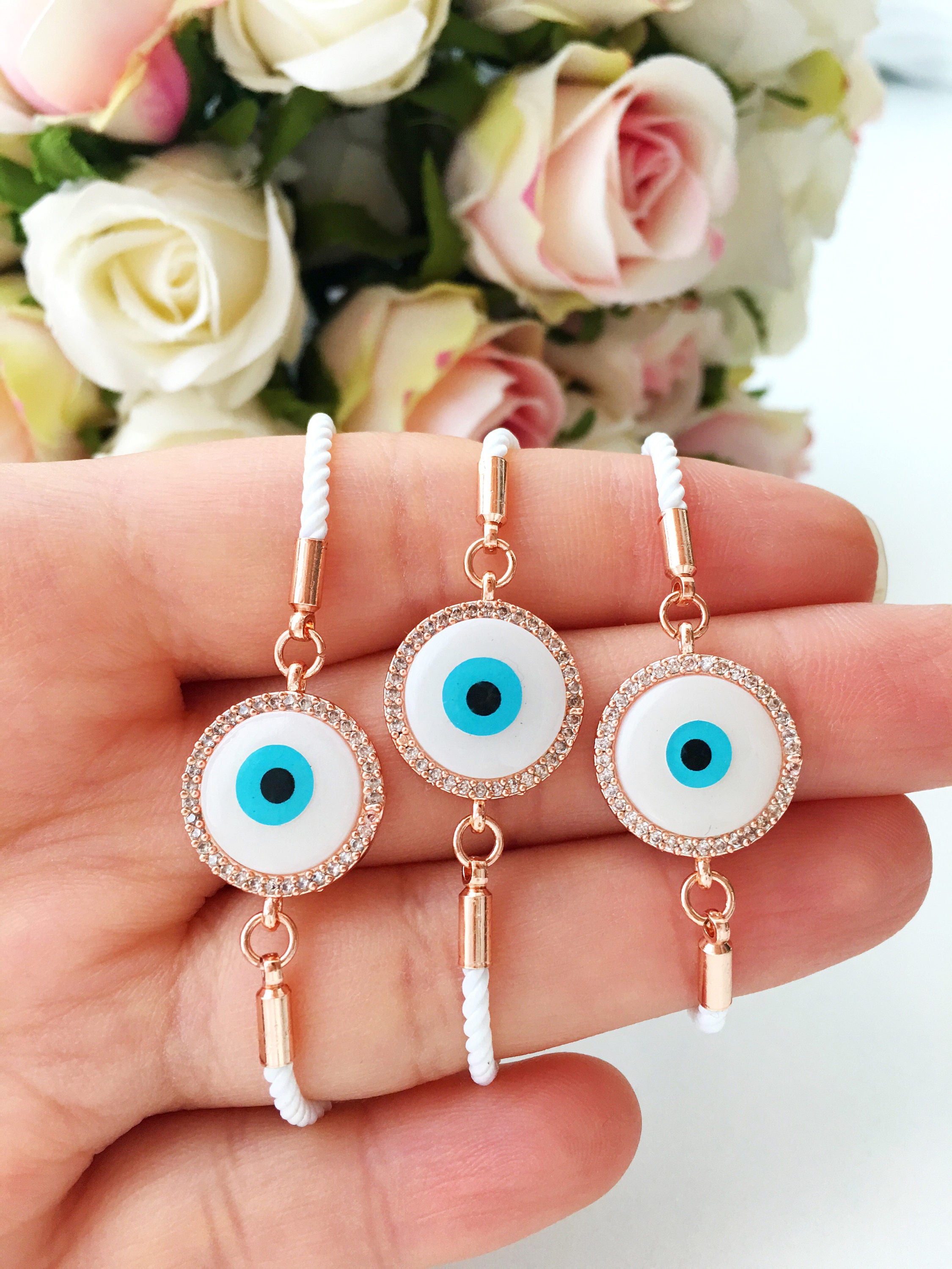 A beautifully crafted White Evil Eye Bracelet featuring a mother of pearl centerpiece, adjustable white string, and zirconia accents.