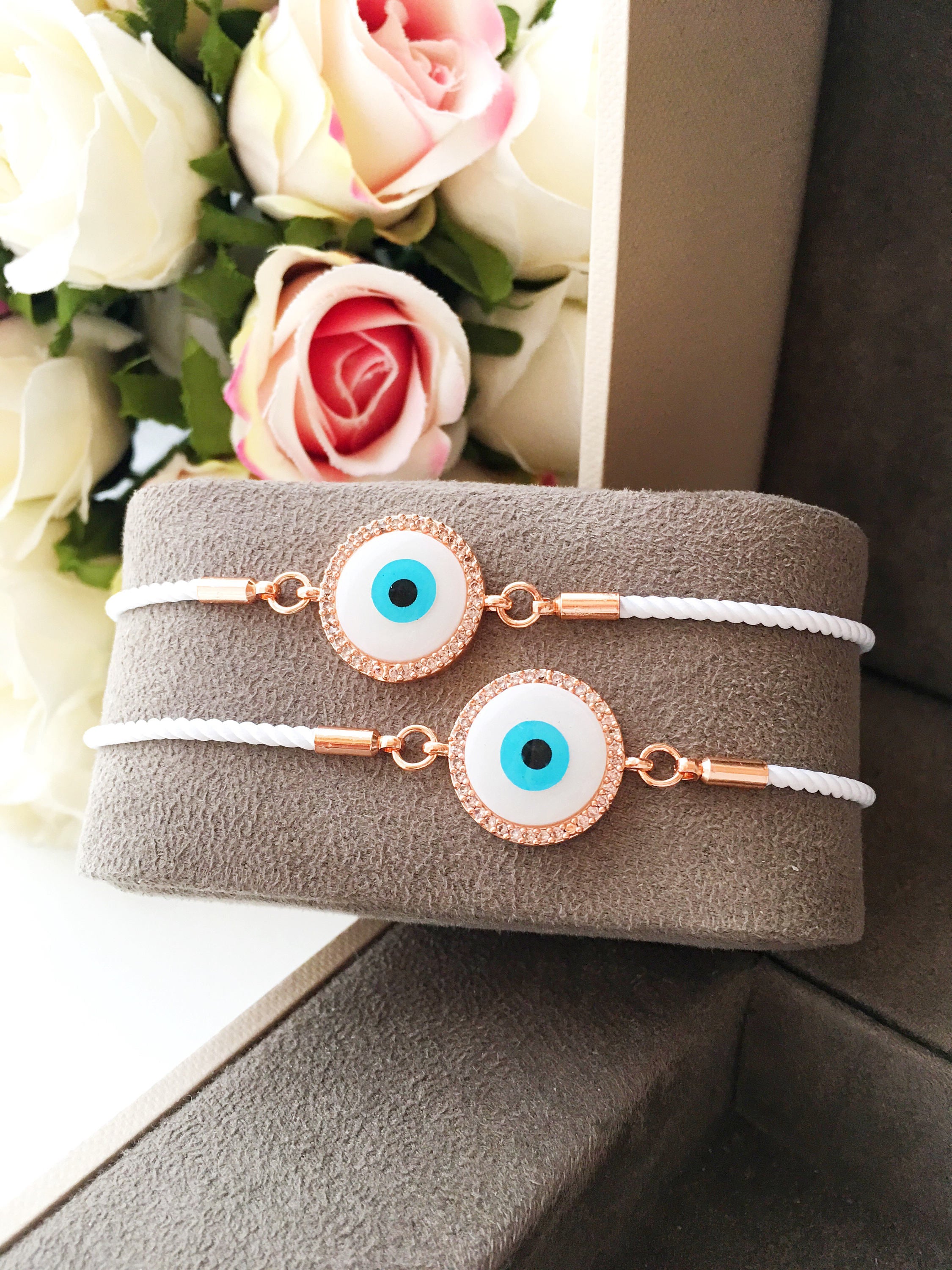 A beautifully crafted White Evil Eye Bracelet featuring a mother of pearl centerpiece, adjustable white string, and zirconia accents.