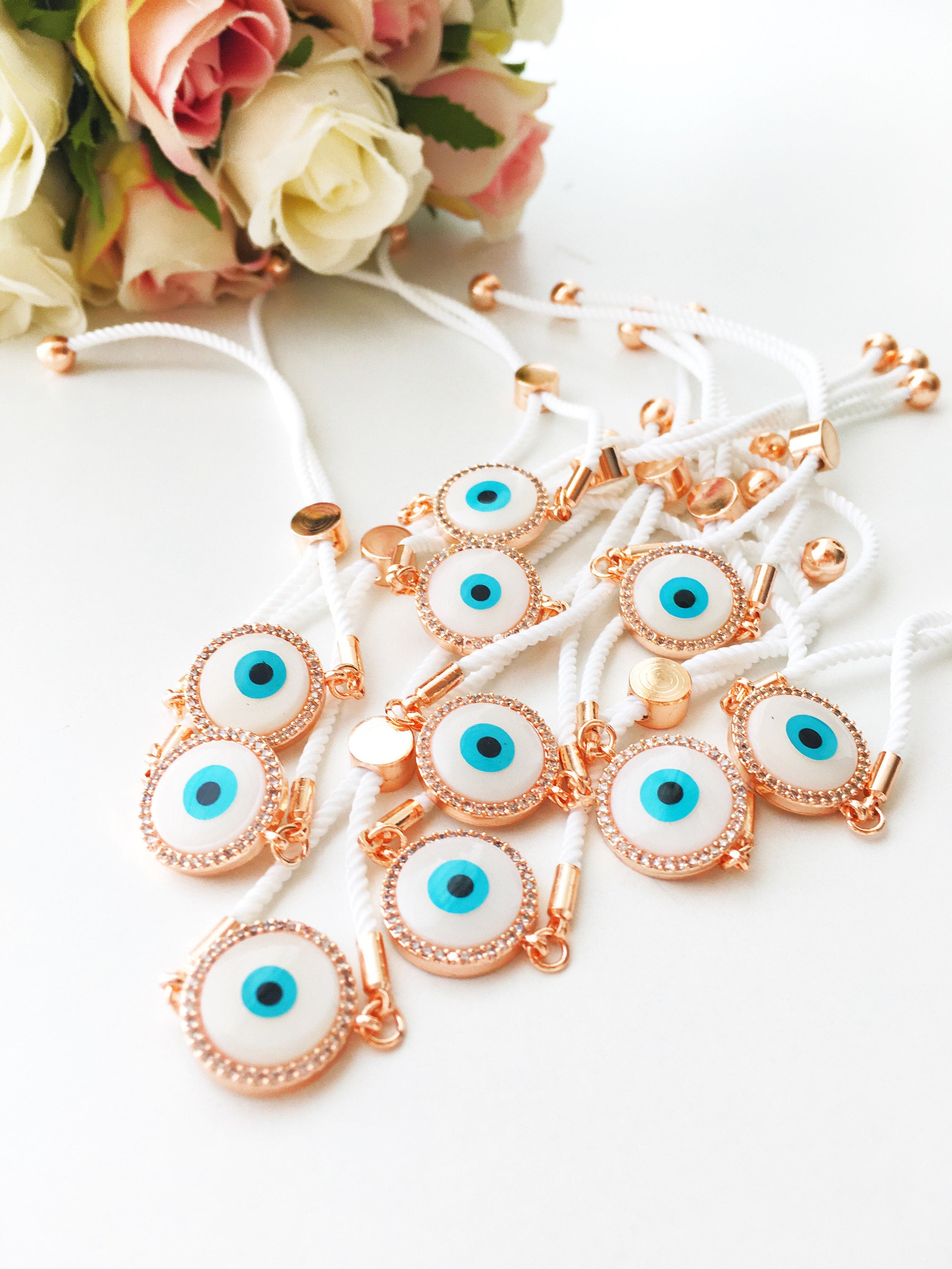 A beautifully crafted White Evil Eye Bracelet featuring a mother of pearl centerpiece, adjustable white string, and zirconia accents.