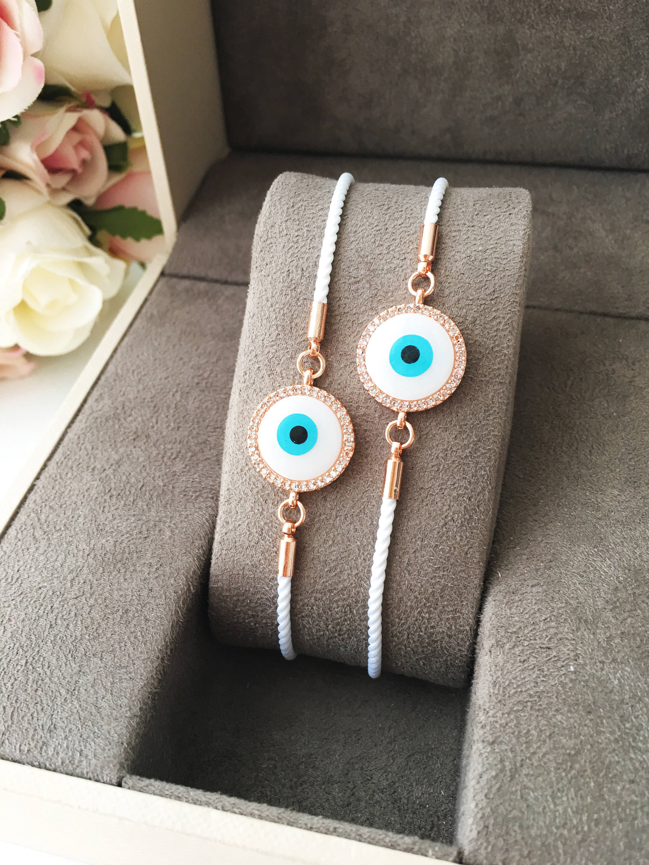 A beautifully crafted White Evil Eye Bracelet featuring a mother of pearl centerpiece, adjustable white string, and zirconia accents.