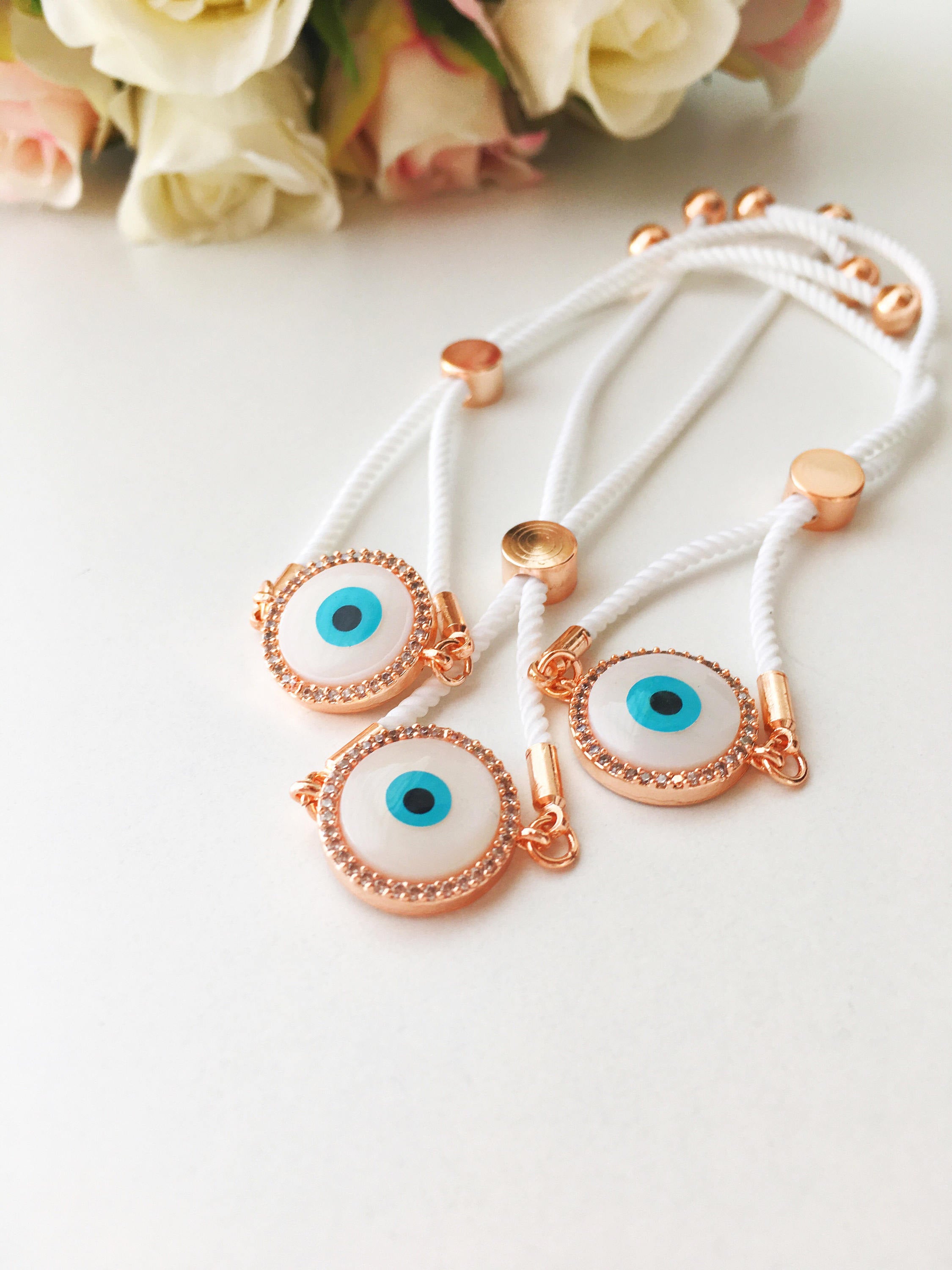 A beautifully crafted White Evil Eye Bracelet featuring a mother of pearl centerpiece, adjustable white string, and zirconia accents.