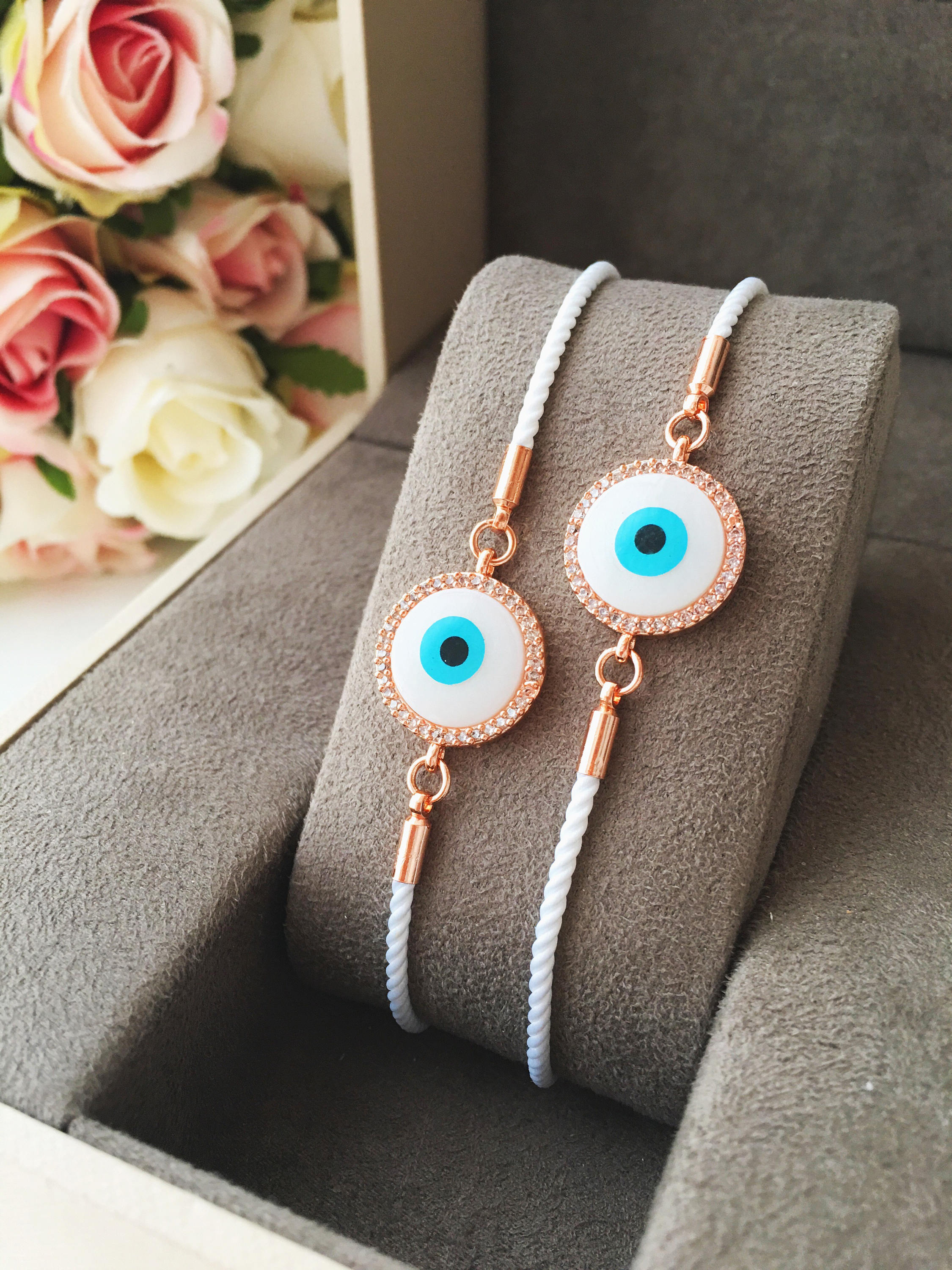 A beautifully crafted White Evil Eye Bracelet featuring a mother of pearl centerpiece, adjustable white string, and zirconia accents.