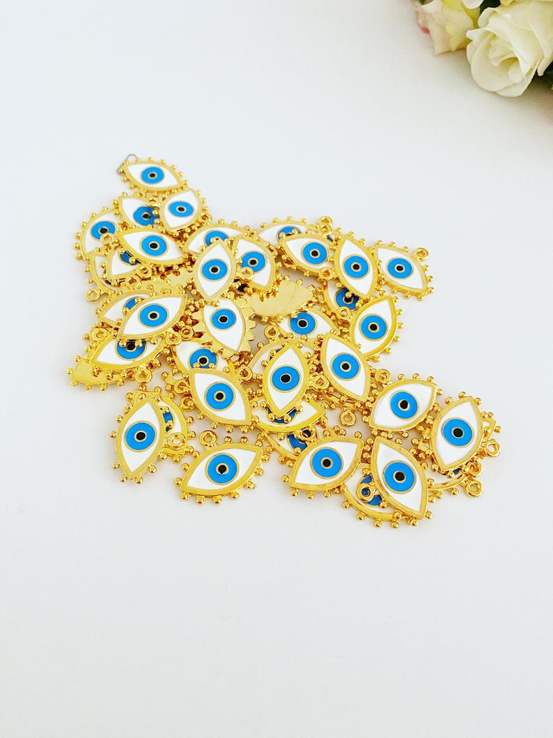 A beautiful White Evil Eye Charm featuring an enamel bead design with a gold evil eye pendant, perfect for jewelry making.