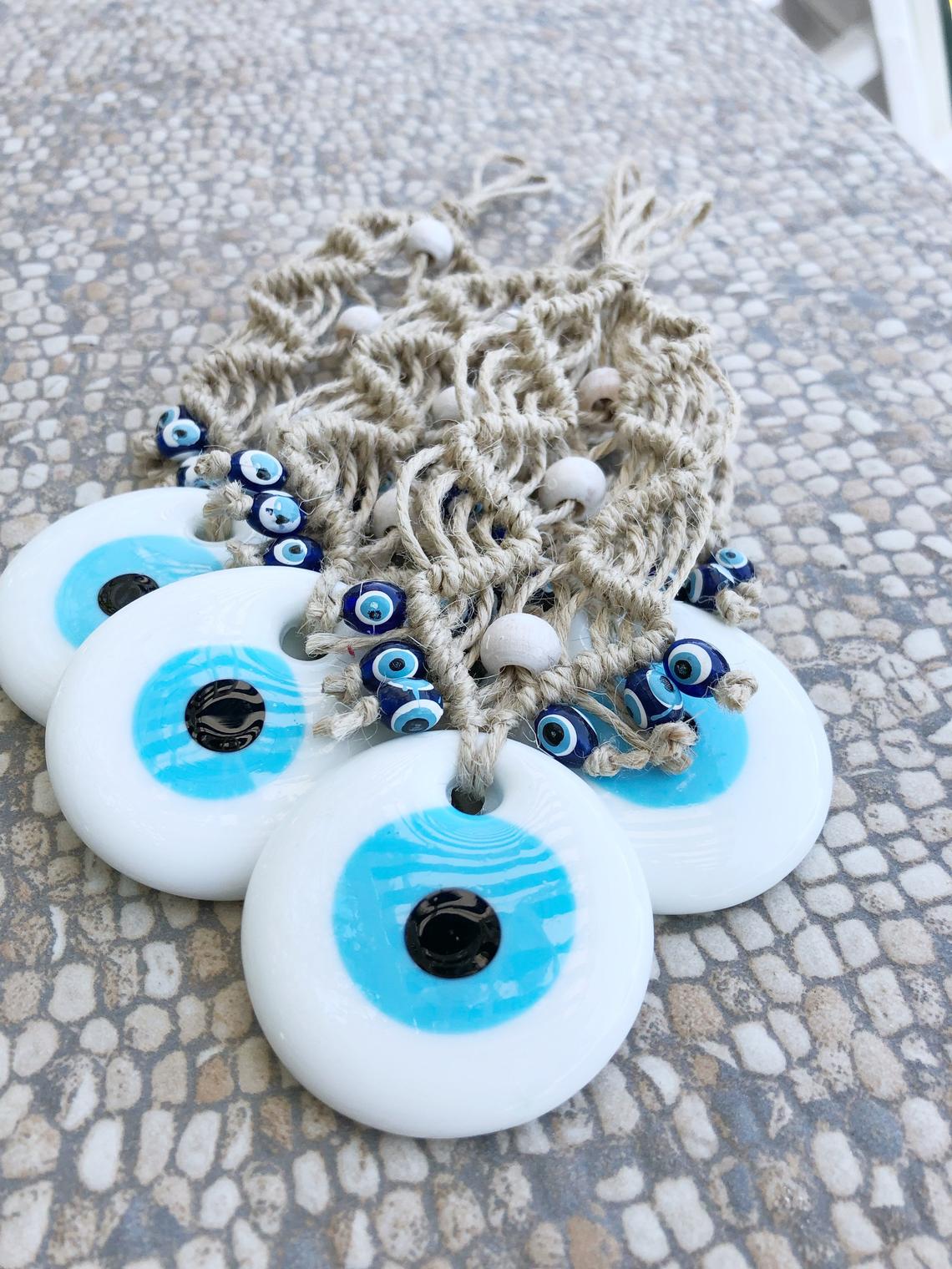 A beautiful white evil eye wall hanging ornament, featuring a large white bead symbolizing protection, perfect for Christmas tree decoration.