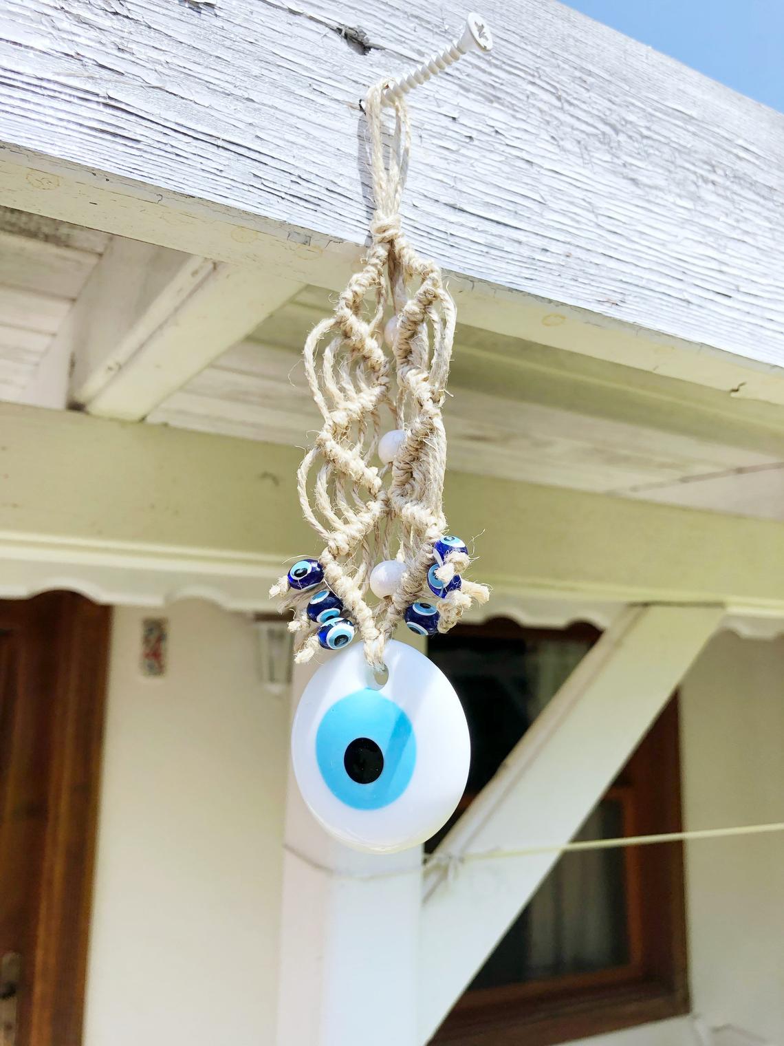 A beautiful white evil eye wall hanging ornament, featuring a large white bead symbolizing protection, perfect for Christmas tree decoration.