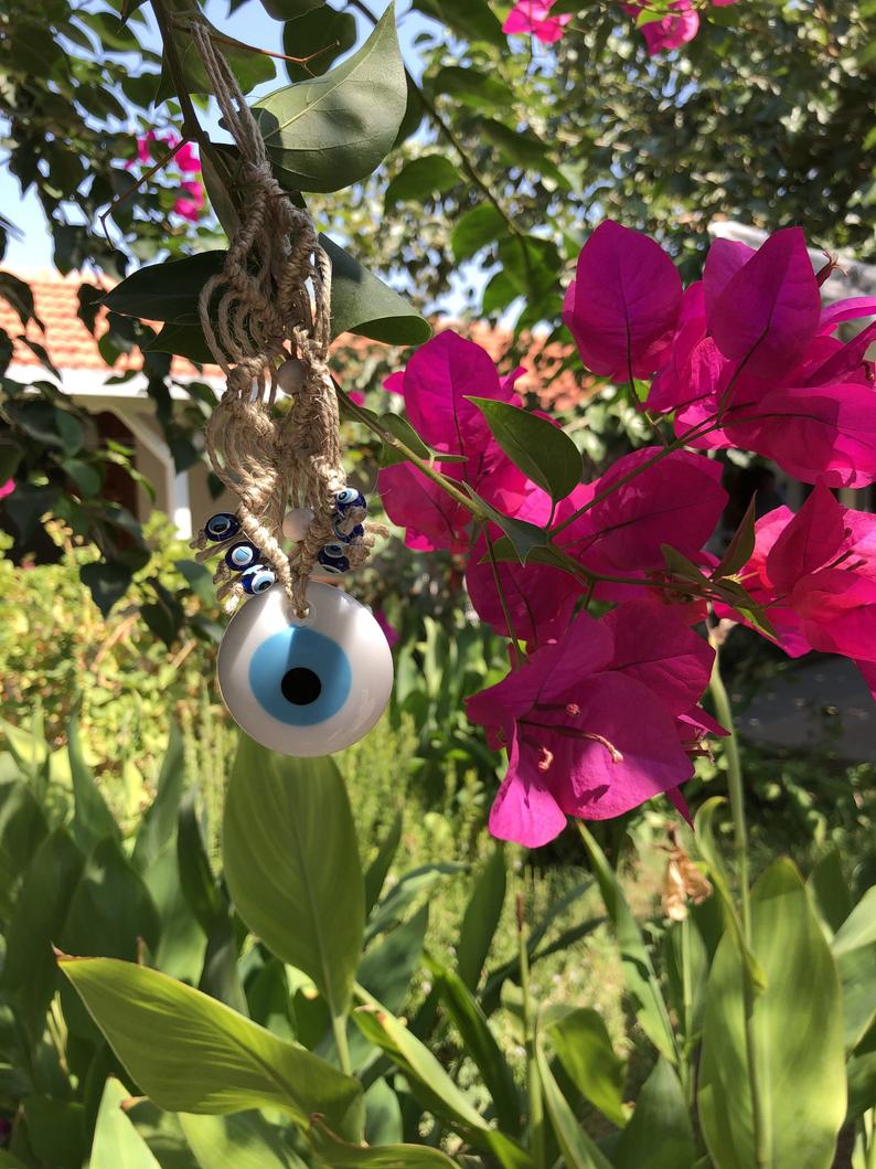 A beautiful white evil eye wall hanging ornament, featuring a large white bead symbolizing protection, perfect for Christmas tree decoration.