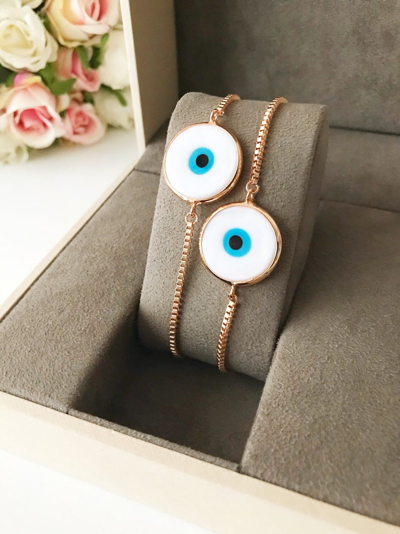 A beautiful White Murano Evil Eye Bracelet featuring a handmade Murano glass charm on an adjustable rose gold chain, showcasing elegance and durability.